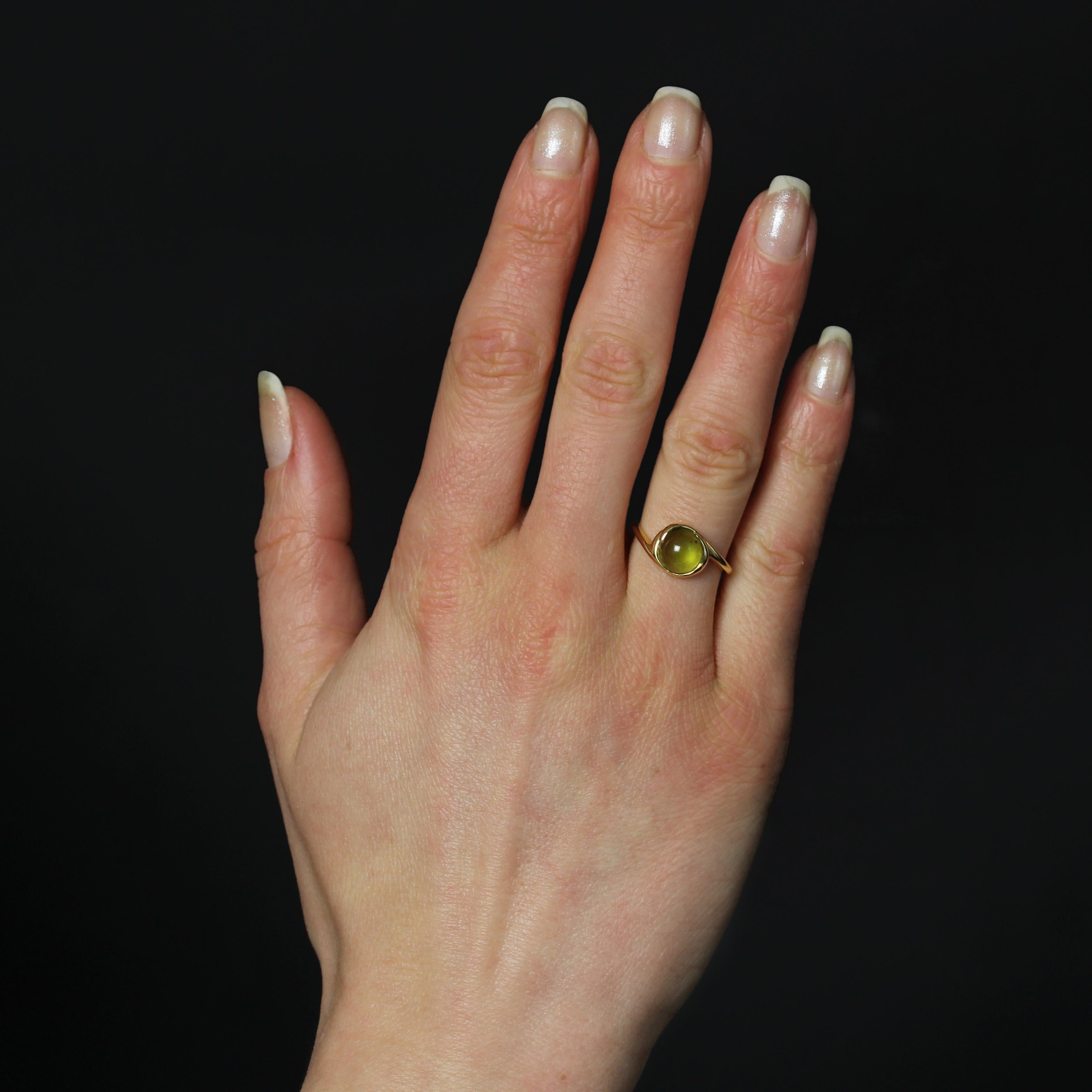 Ring in 18 karat yellow gold.
A delightful peridot ring, featuring a slender yellow gold band encircling a cabochon-cut peridot. 
Height : 12.1 mm approximately, width : 16 mm approximately, thickness : 5 mm approximately, width of ring at base :