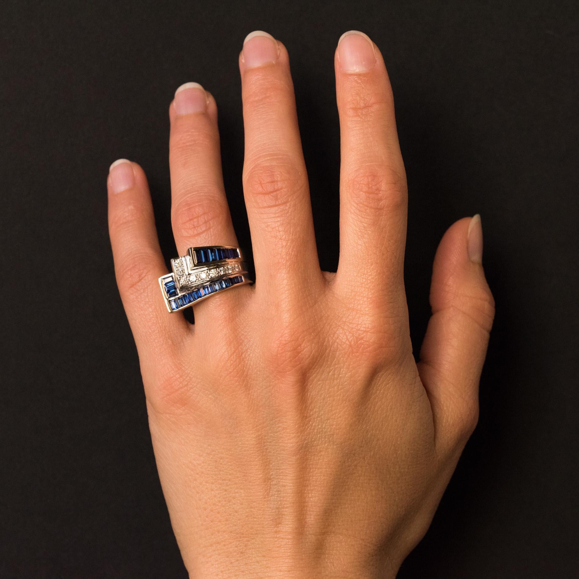 Ring in 18 karats white gold, eagle's head hallmark.
Asymmetric, this art deco ring is made up of 3 overlapping rectangular motifs, alternately set with calibrated blue sapphires, brilliant- cut diamonds and calibrated sapphires.
Total weight of