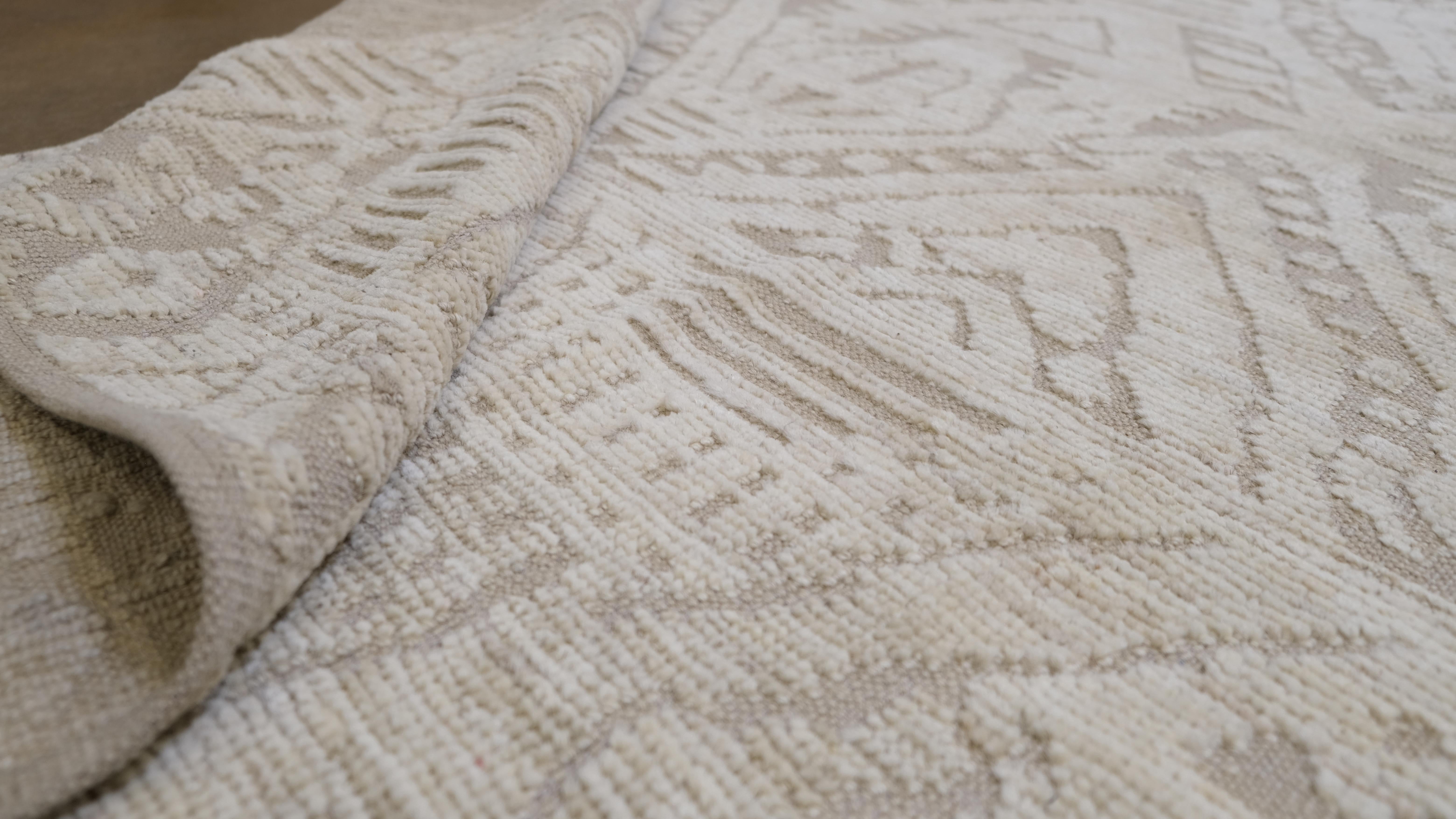 Realza tu espacio con la elegancia atemporal de esta alfombra de lana anudada a mano, con un sutil diseño tribal de rombos en tranquilos tonos neutros. Esta obra maestra de gran tamaño combina sin esfuerzo la artesanía tradicional con la