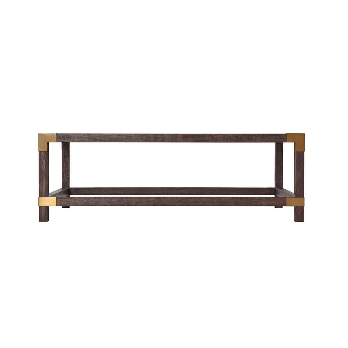 With a solid textured beech frame in a dark Cardamon finish, with brushed brass corners. With an inset tempered glass top with a stretcher base.

Dimensions: 54