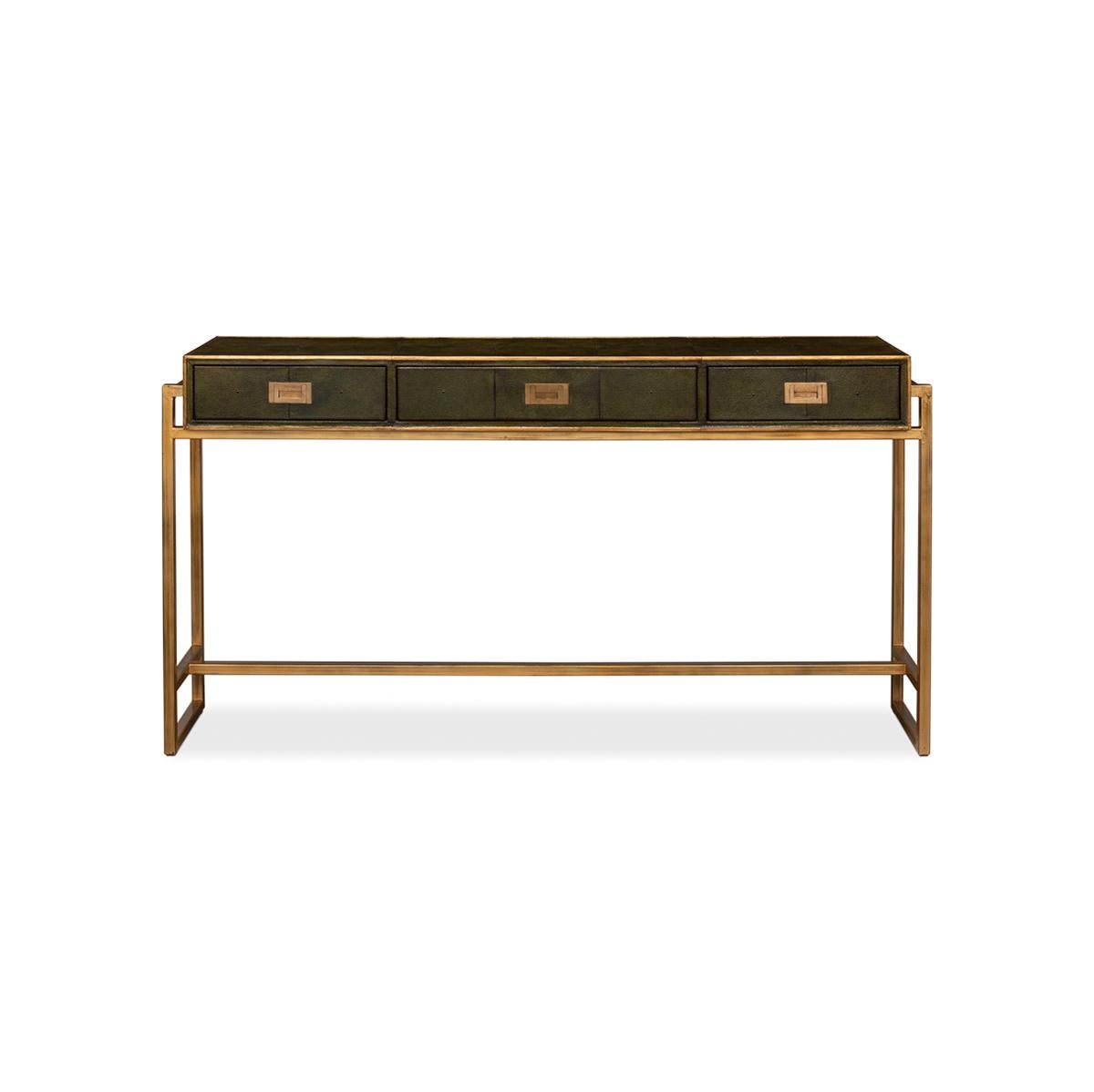Our Modern Campaign Green Leather Wrapped Console Table is the perfect fusion of vintage and contemporary design. The dark green embossed leather wrapping is not only sleek, but it is also the perfect backdrop for the elegant gilded trim and brass