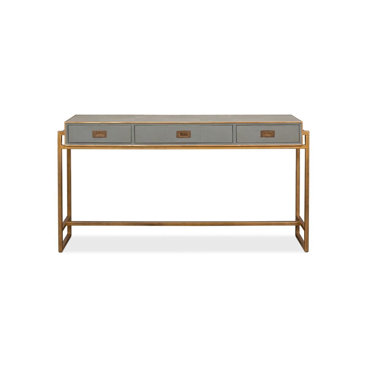 Our Modern Campaign Grey Leather Wrapped Console Table is the perfect fusion of vintage and contemporary design. The storm grey embossed leather wrapping is not only sleek, but it is also the perfect backdrop for the elegant gilded trim and brass