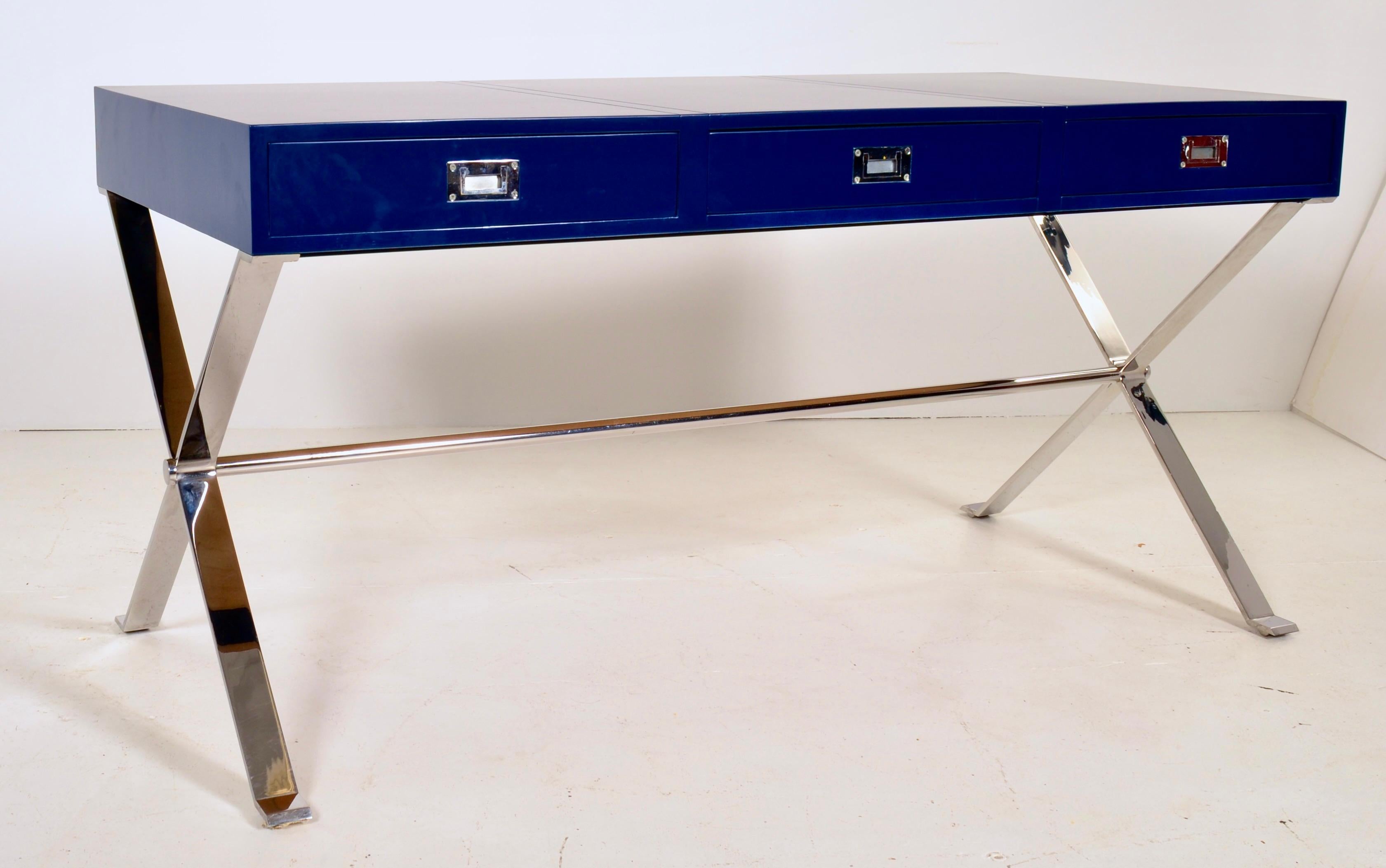 Handsome polished steel and dark blue lacquered desk in the campaign style. Heavy polished steel base in good condition. Nice large top featuring a center drawer and two side drawers. Newly lacquered in BM Old Navy, satin finish. Very fine condition.