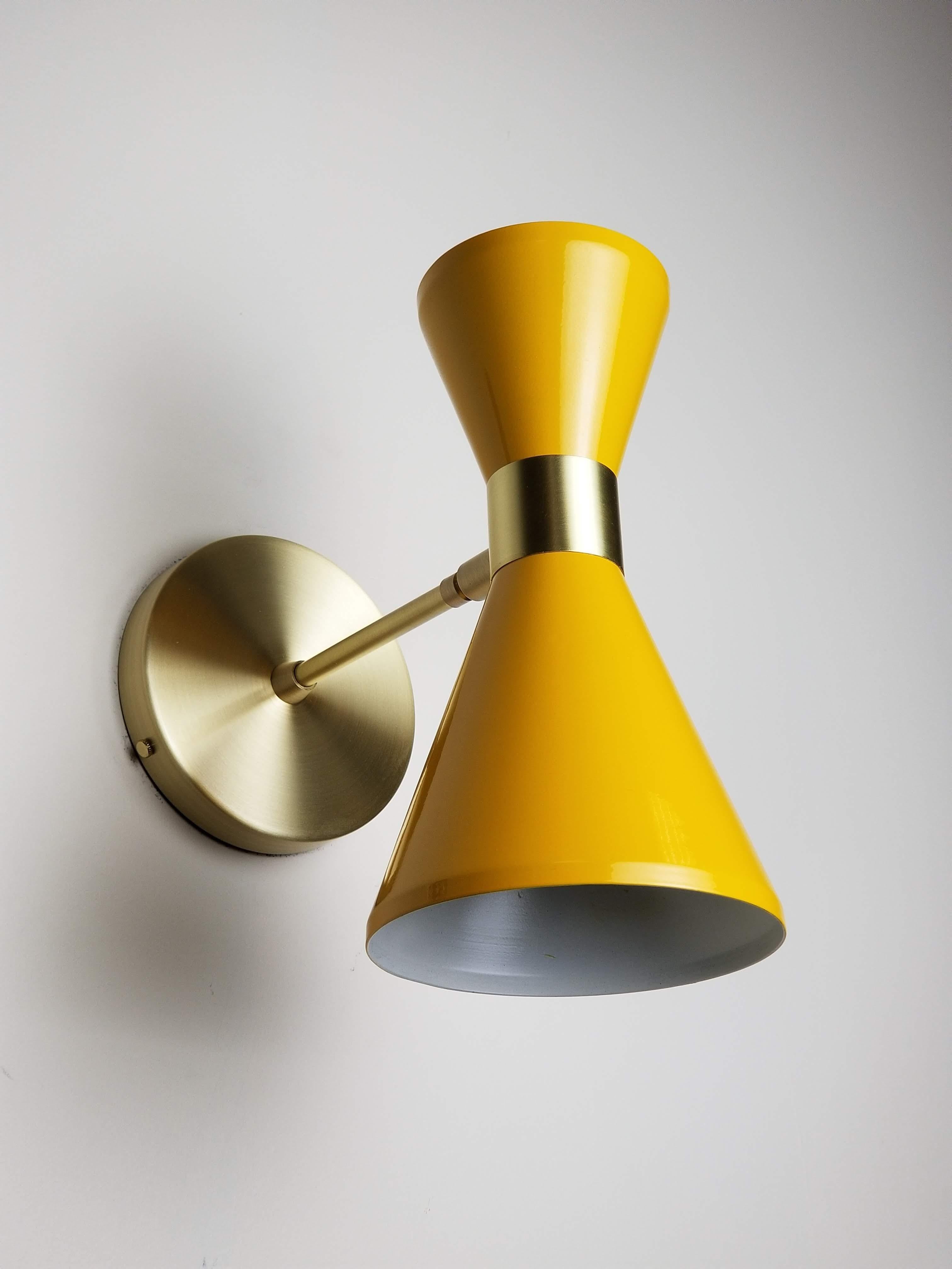 The Campana wall sconce or reading light shown in natural brass and saffron enamel fabricated in NYC by Blueprint Lighting, 2018. The wide band and distinctly bevelled edge makes the Campana a strong design statement. Swiveling head allows for cone