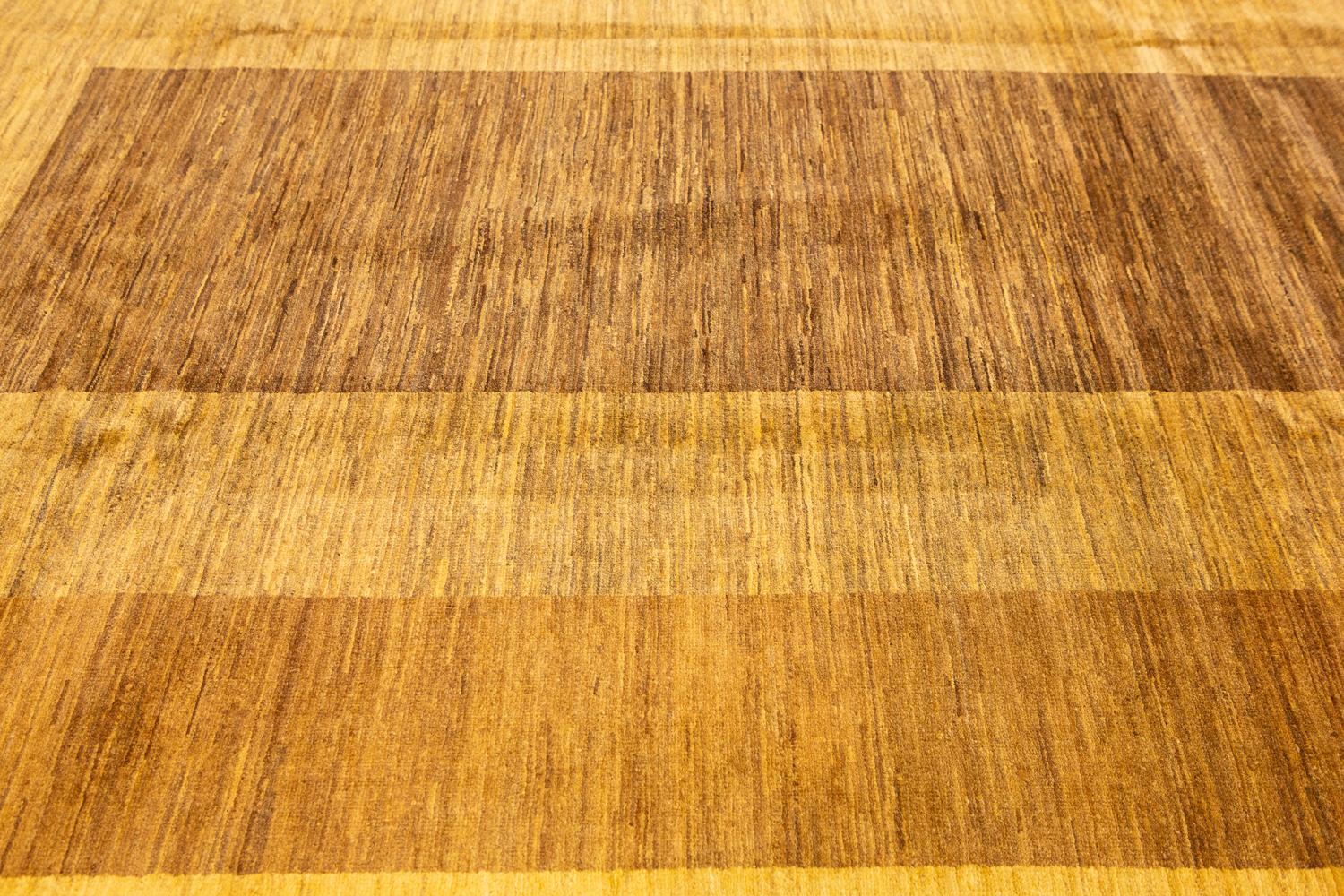 Ce tapis vibrant et élégant est parfait pour tous ceux qui souhaitent ajouter une touche de luxe à leur maison. Noué à la main au Pakistan, il présente un magnifique motif jaune et marron qui s'intègre parfaitement dans n'importe quelle pièce. Le