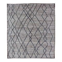Tappeto tribale moderno e informale in lana con disegno a flusso libero nei colori crema e blu.