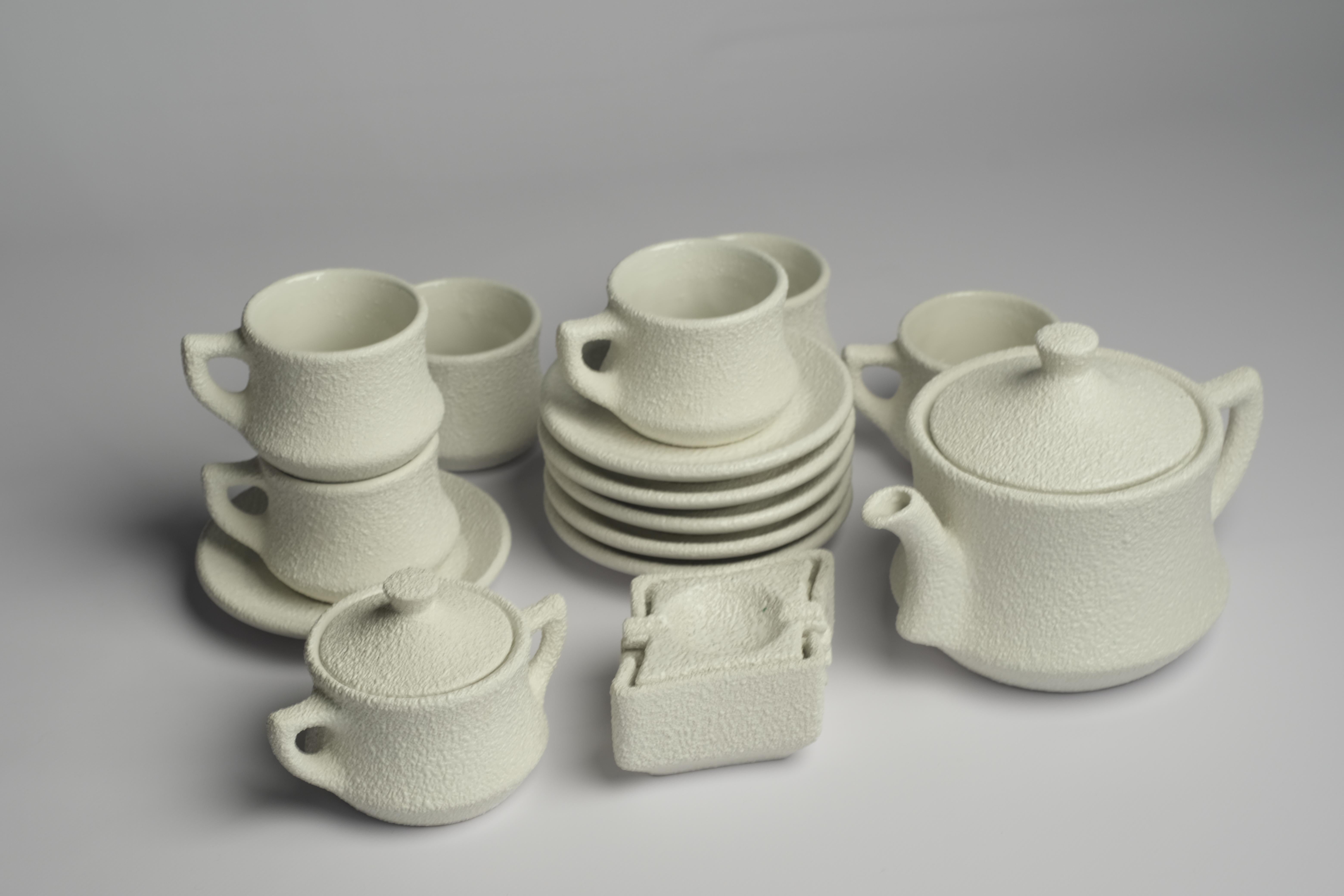 Mid-Century Modern ceramic coffee/tea set glazed in a granulated sand textured stucco finish. The combination of the early 20th century lines and the more modern rugged texture, makes this set rather eye-catching and interesting. 

Set contains of
