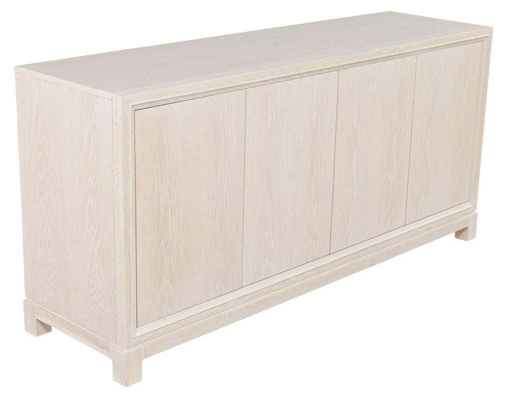 Modern Cerused oak sideboard Buffet in natural wash finish. Featuring natural whitewash ceruse finish with contrasting white grains. Doors open with sleek push touch latches, height adjustable shelves and hideaway center drawer. Price includes