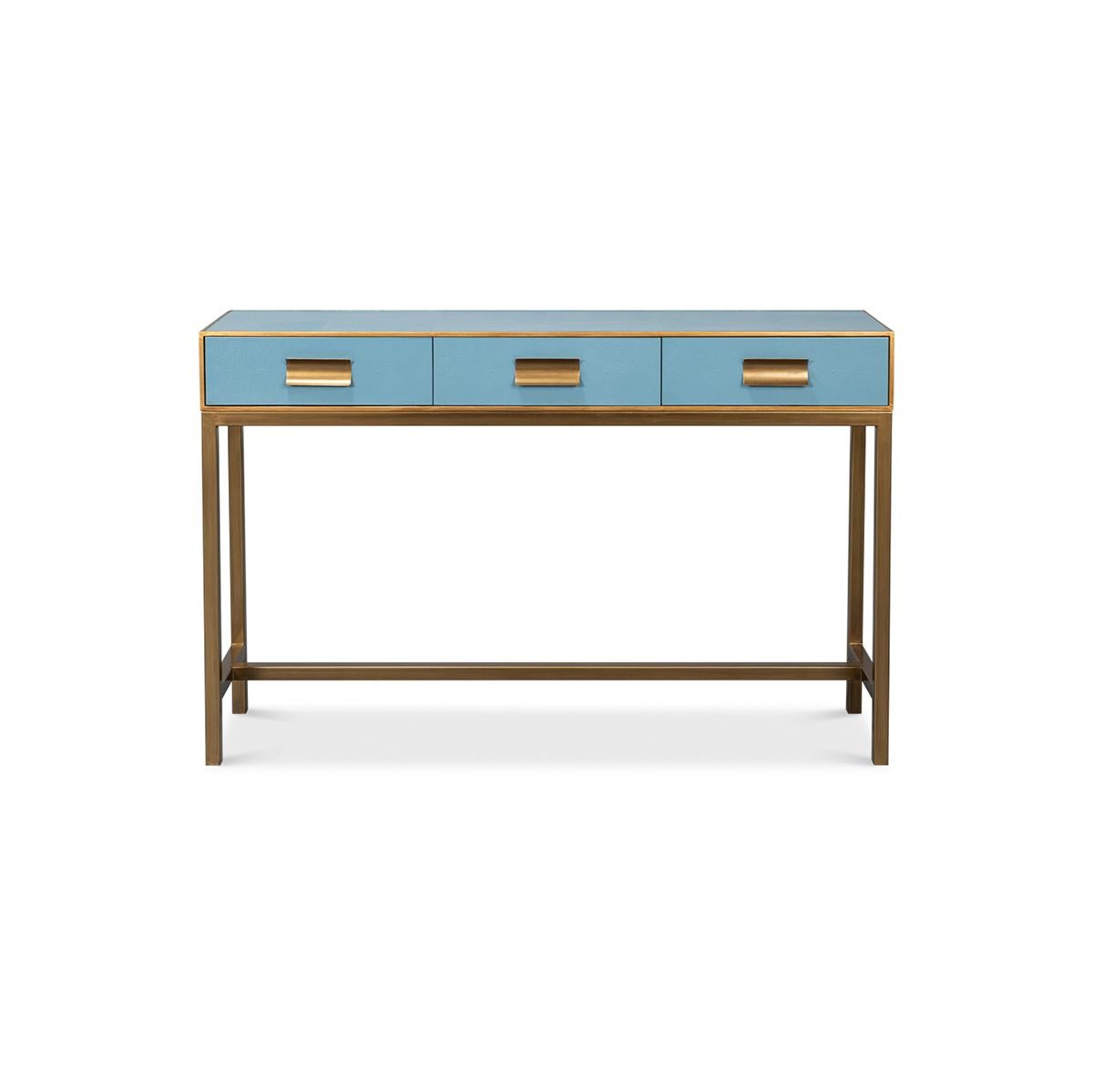 This piece, beautifully crafted with a luxurious leather exterior in a serene chambray blue, is accentuated with delicate gilt trim, adding a hint of glamour to its modern design. The console measures 54