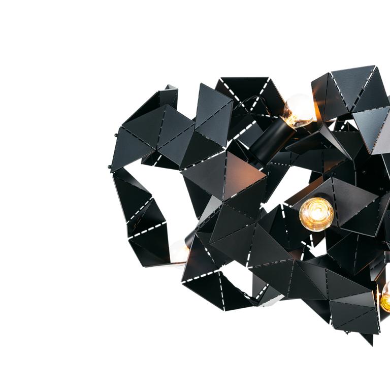 The Fractal, a modern chandelier in black matt finish, is designed by William Brand, founder of Brand van Egmond. The play between the unexpected geometry of the surfaces and the characteristics of the metal changes the light from every point of