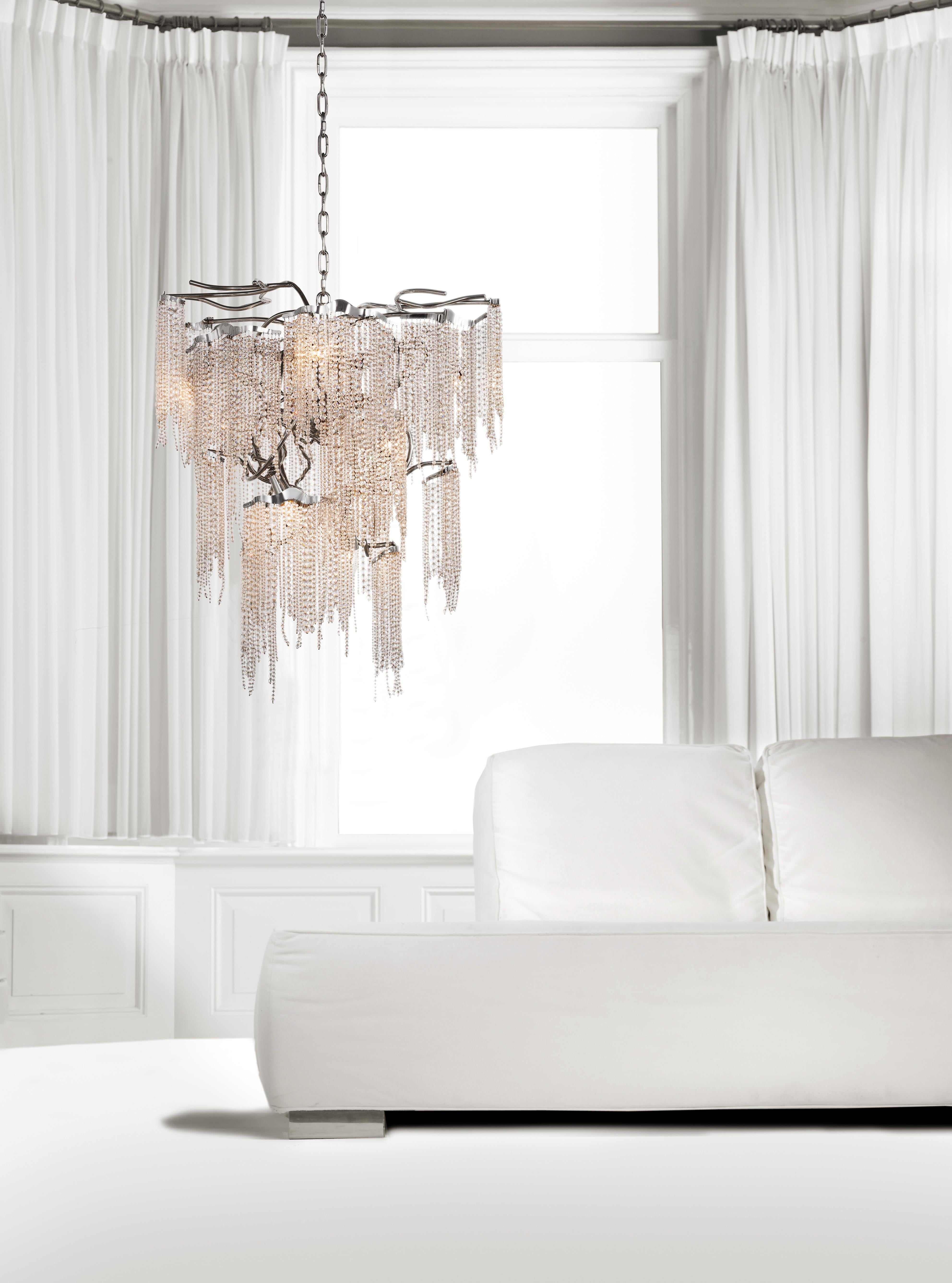 This modern chandelier in a conical shape, in a nickel finish with crystals is part of the Victoria collection, designed by William Brand of Brand van Egmond.

Before you see it, the sparkling light reaches your eyes in full splendour. The fresh