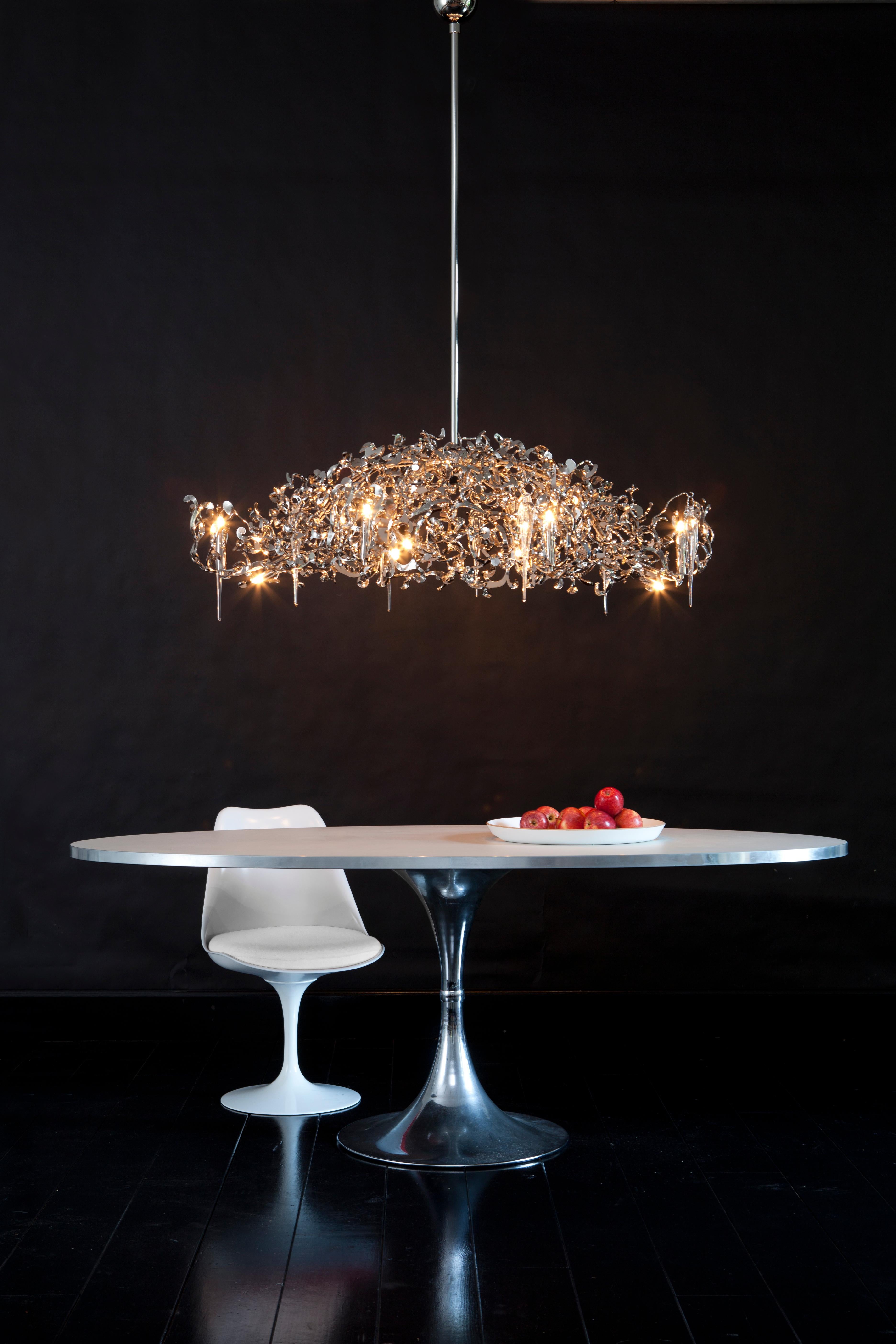 This modern chandelier in an oval shape and nickel finish is part of the Flower Power collection, designed by William Brand, founder of Brand van Egmond. Using the latest techniques to cut flowery sensual shapes out of steel plates, Flower Power is
