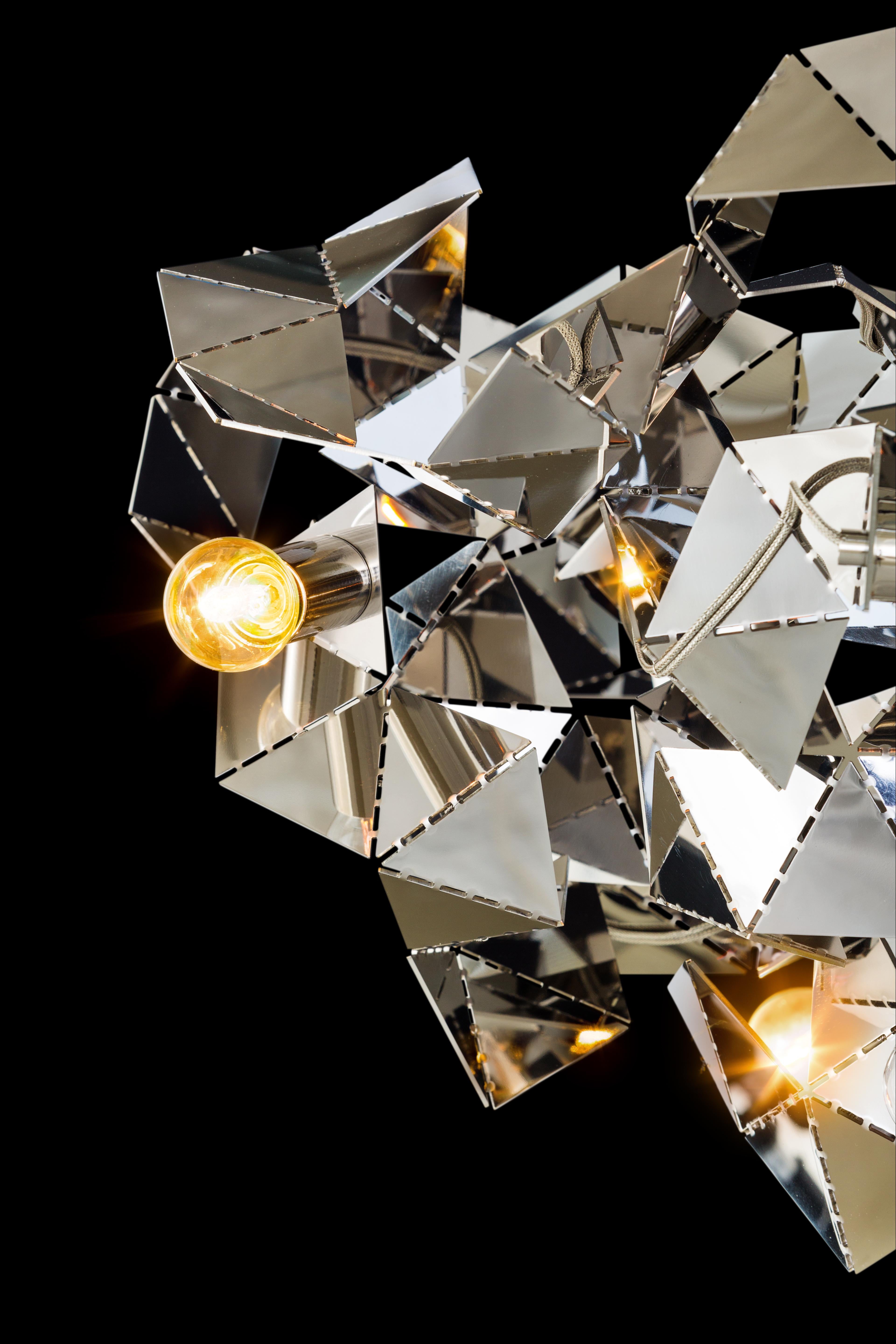 The Fractal, a modern chandelier in stainless steel, is designed by William Brand, founder of Brand van Egmond. The play between the unexpected geometry of the surfaces and the characteristics of the metal changes the light from every point of view.
