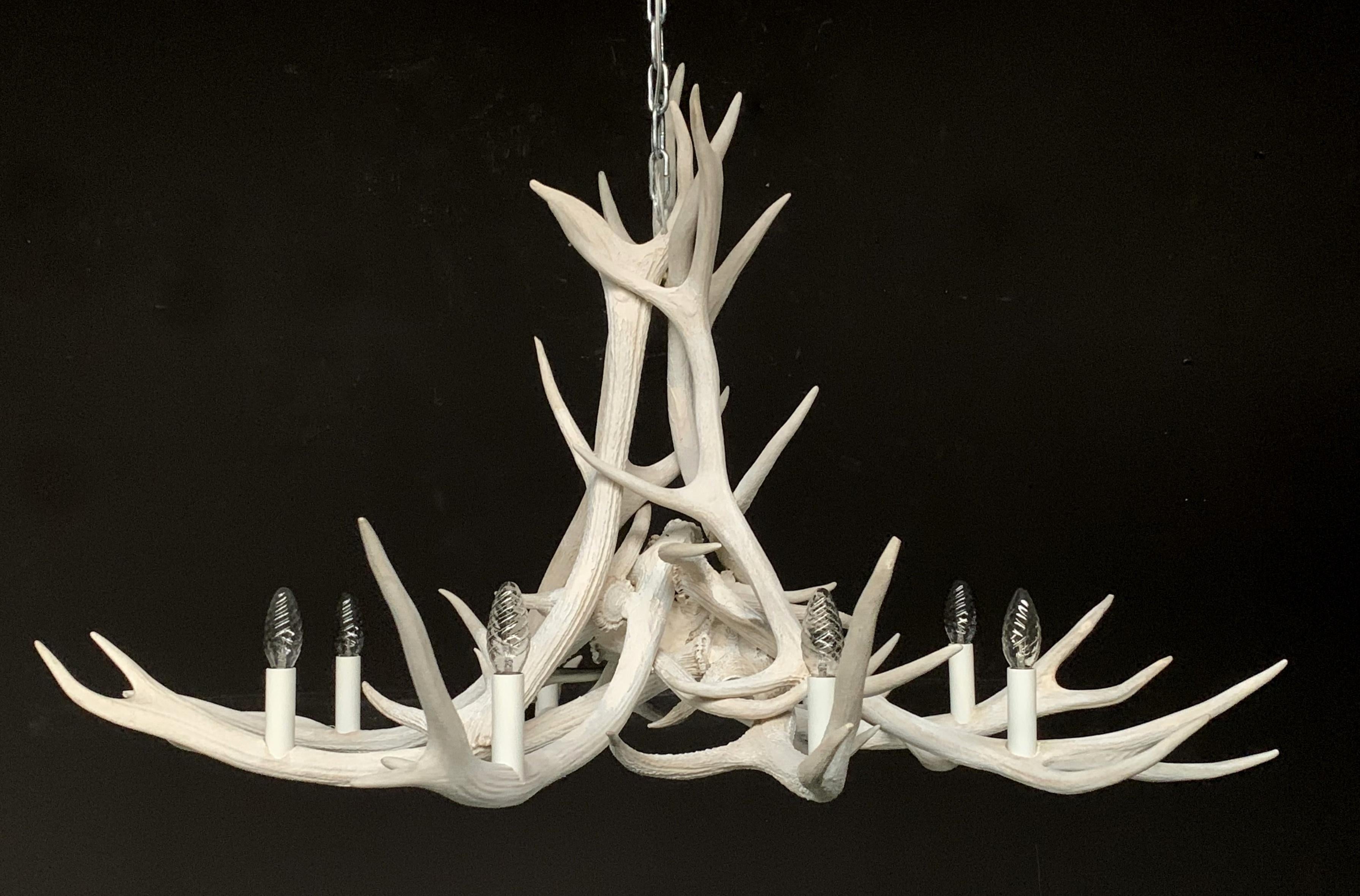 Modern chandelier made of antlers (HG 253). The chandelier is made of bleached red deer antler. The electrical wiring is concealed in the antlers. We can make any antler chandelier entirely according to your wishes.