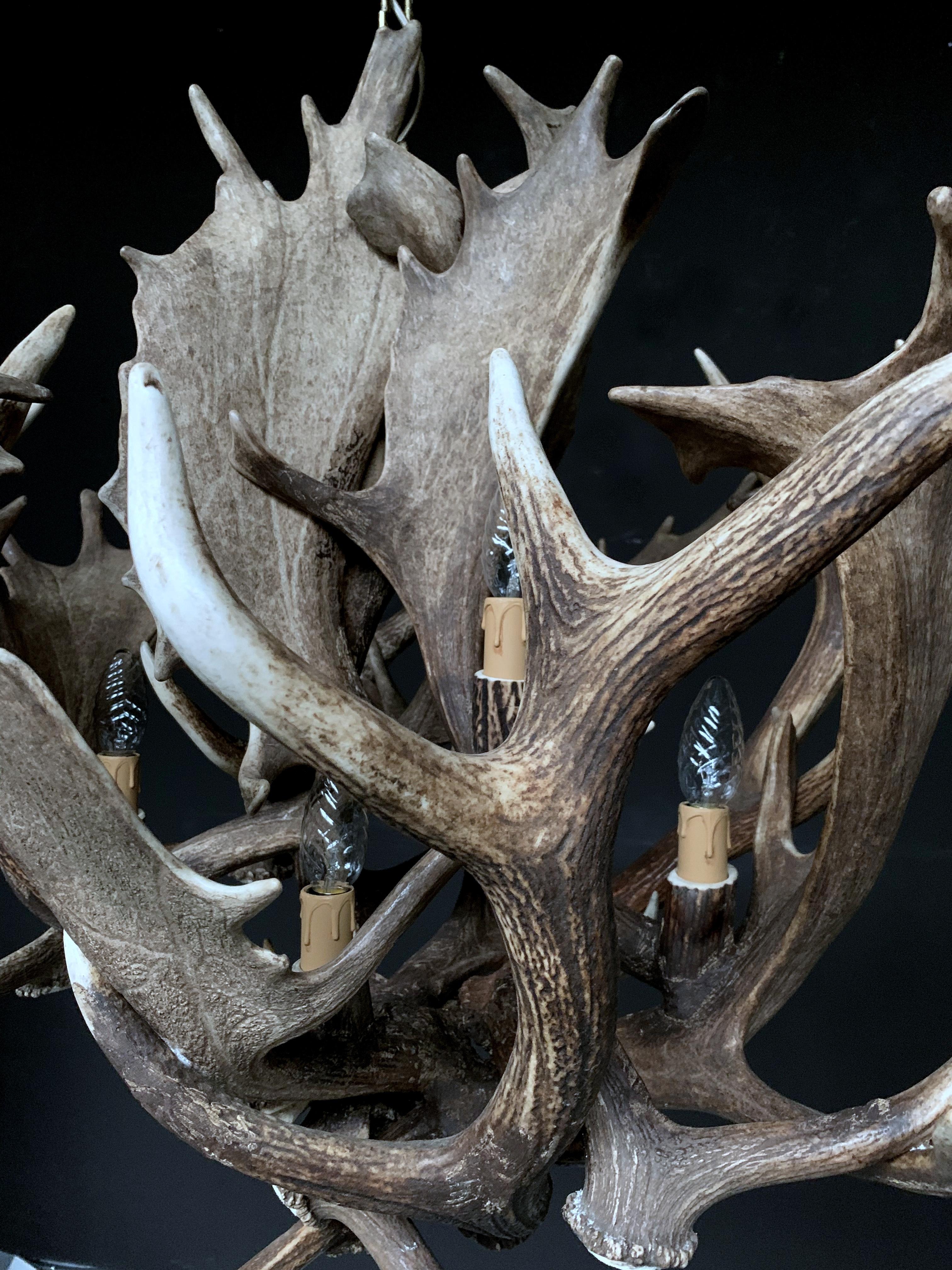 Modern chandelier made of antlers (HG 241). The chandelier is made of fallow deer antler. The electrical wiring is concealed in the antlers and the quality of our chandeliers is really high. We can make any antler chandelier entirely according to