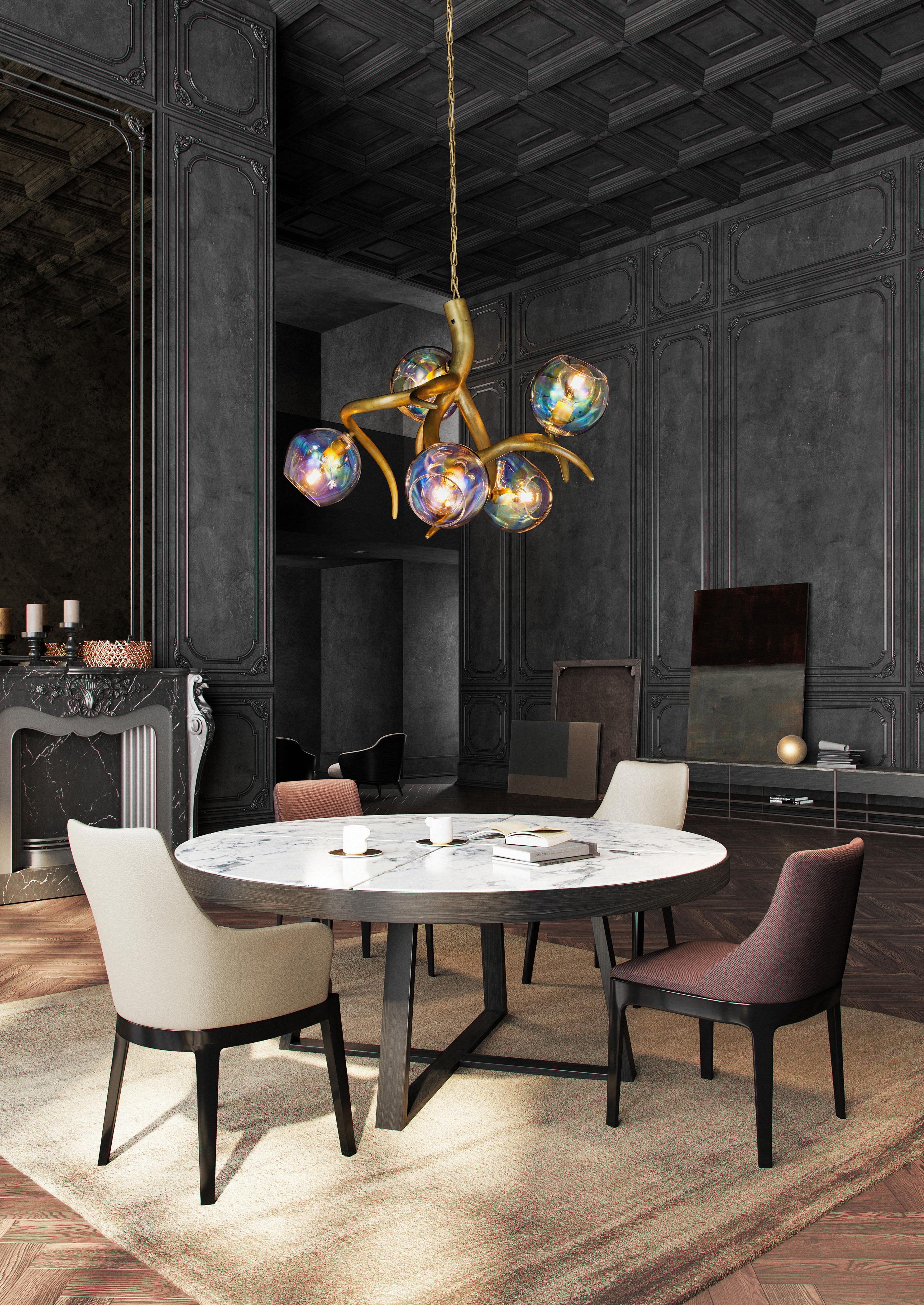 The Ersa, a modern chandelier in a brass burnished finish with iridescent glass spheres, is designed by William Brand, founder of Brand van Egmond. Crafted by hand in the atelier of Brand van Egmond, the chandelier is available in three different