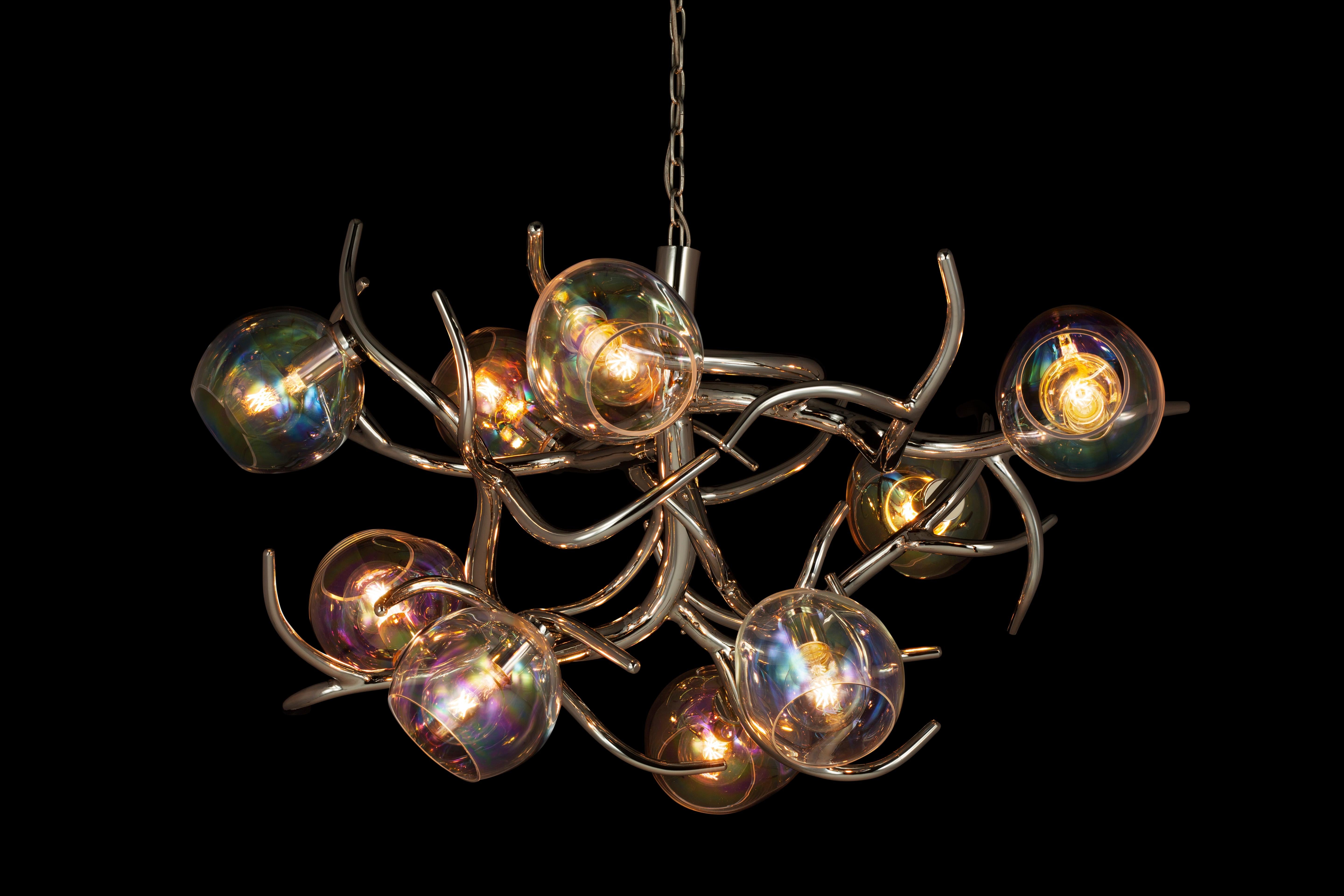 The Ersa, a modern chandelier in a nickel finish with iridescent glass spheres, is designed by William Brand, founder of Brand van Egmond. Created as the statement chandelier in the interior, this Ersa is available in three different models round,