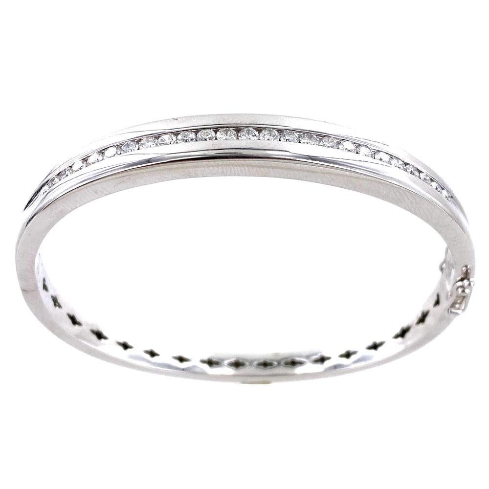 Modern diamond bangle bracelet crafted in solid 14 karat white gold. The 25 channel set round brilliant cut diamonds weigh approximately 1.25 carats. The bangle measures 8mm in width, and 7 inches in internal circumference. Great to wear alone or