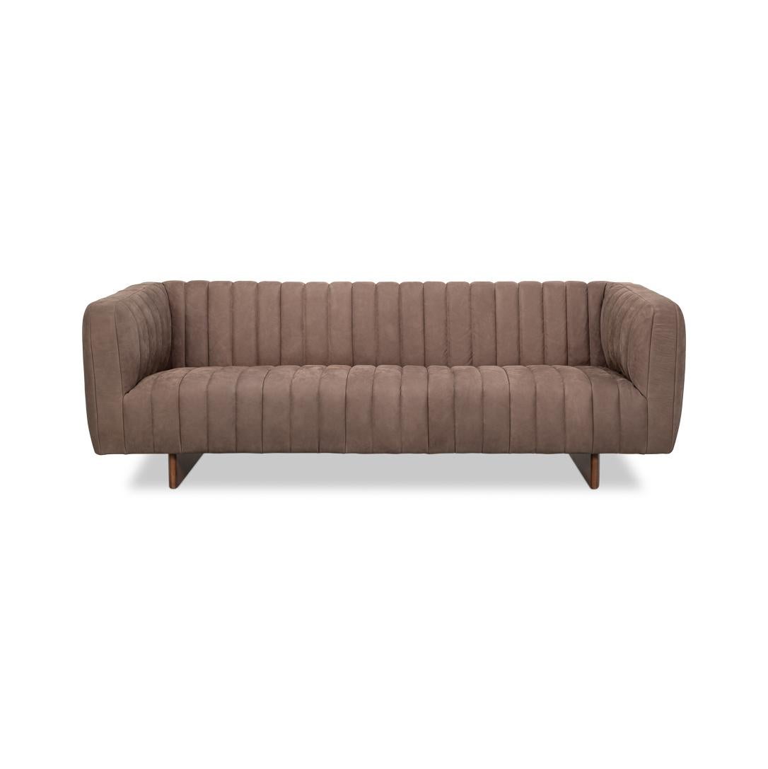Rembourré en cuir de première qualité Scotland Grey, il respire la sophistication, tandis que le capitonnage vertical ajoute de la texture et de l'intérêt visuel.

Soutenu par un socle en bois stylisé, le canapé allie durabilité et charme