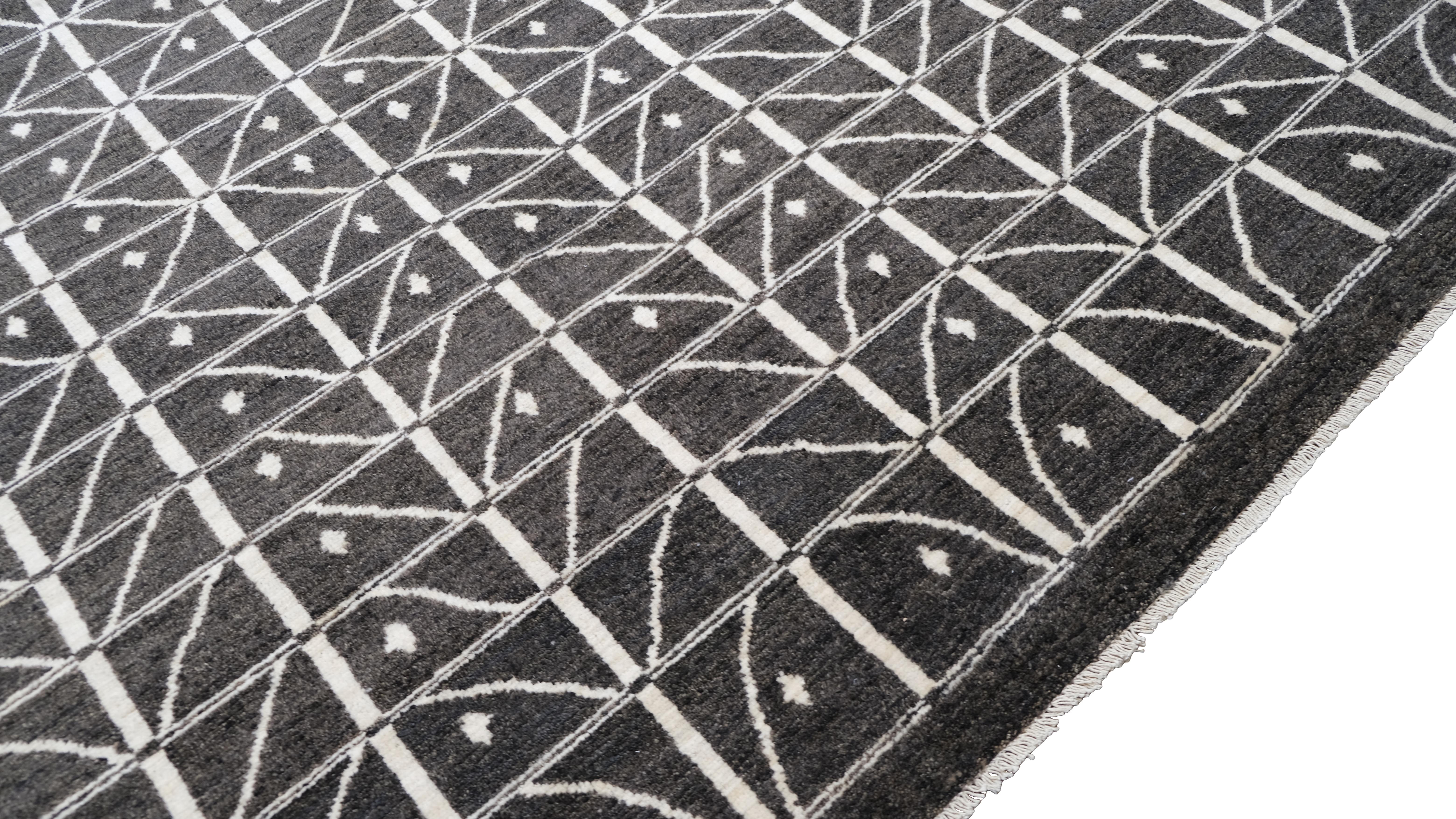 Erhöhen Sie Ihr Wohnambiente mit diesem auffälligen, handgeknüpften Wollteppich in der Farbe Charcoal  Hintergrund mit einem fesselnden weißen geometrischen Gittermuster. Das klare und strukturierte Design passt zu modernen, minimalistischen und