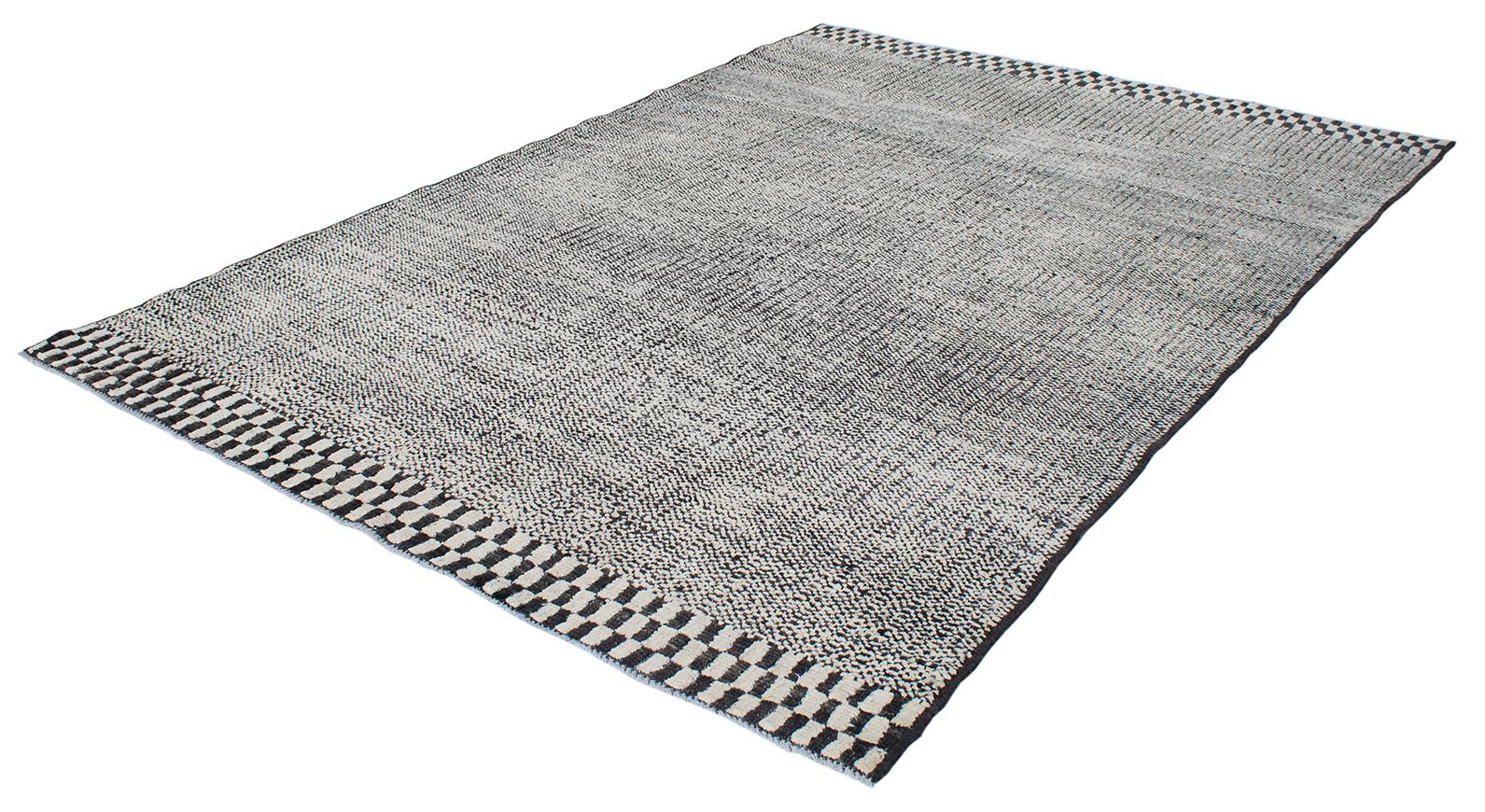 Schöner moderner Teppich, handgeknüpft aus Wolle und Baumwolle. Es hat einen schwarz-weiß karierten Rand oben und unten mit einem linearen Feld.
Der Teppich misst 6'3