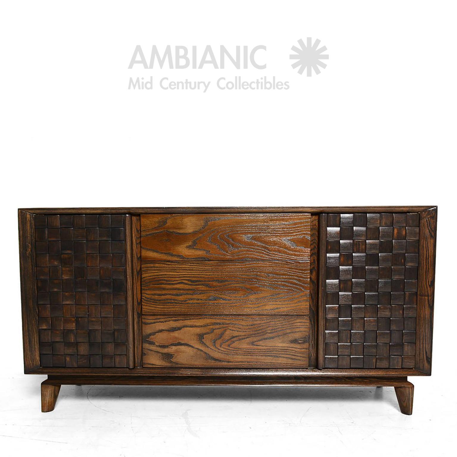 An oak credenza buffet in a basket weave checkered design by architect  interior designer Paul Laszlo for Brown Saltman, USA, 1955. Timeless elegance. Fabulous Fifties.
Credenza has two open storage areas with shelves and three pull-out drawers. All