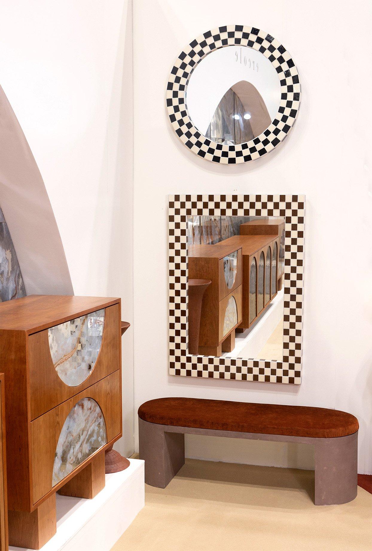 This bespoke modern circular mirror brings a casual, upbeat presence to your home. The checkered mosaic is a mixture of black and ivory glass in layered steps. The border around the mirror is 4