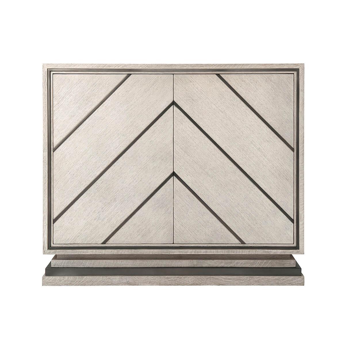 A modern chevron design cabinet with brushed quarter oak veneer in our Gowan finish, two doors with matte tungsten finish chevron overlays enclosing two adjustable shelves and raised on a stepped inset base. 

Dimensions: 40