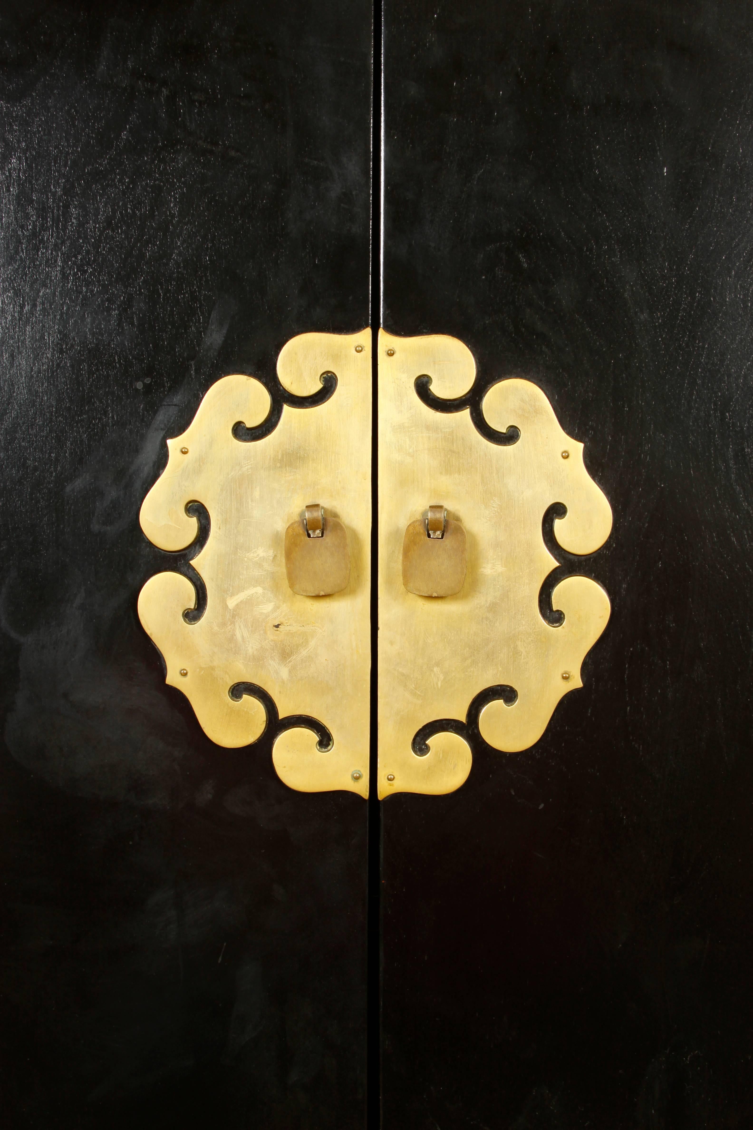 Modern Chinese style gilt-metal mounted ebonized armoire.