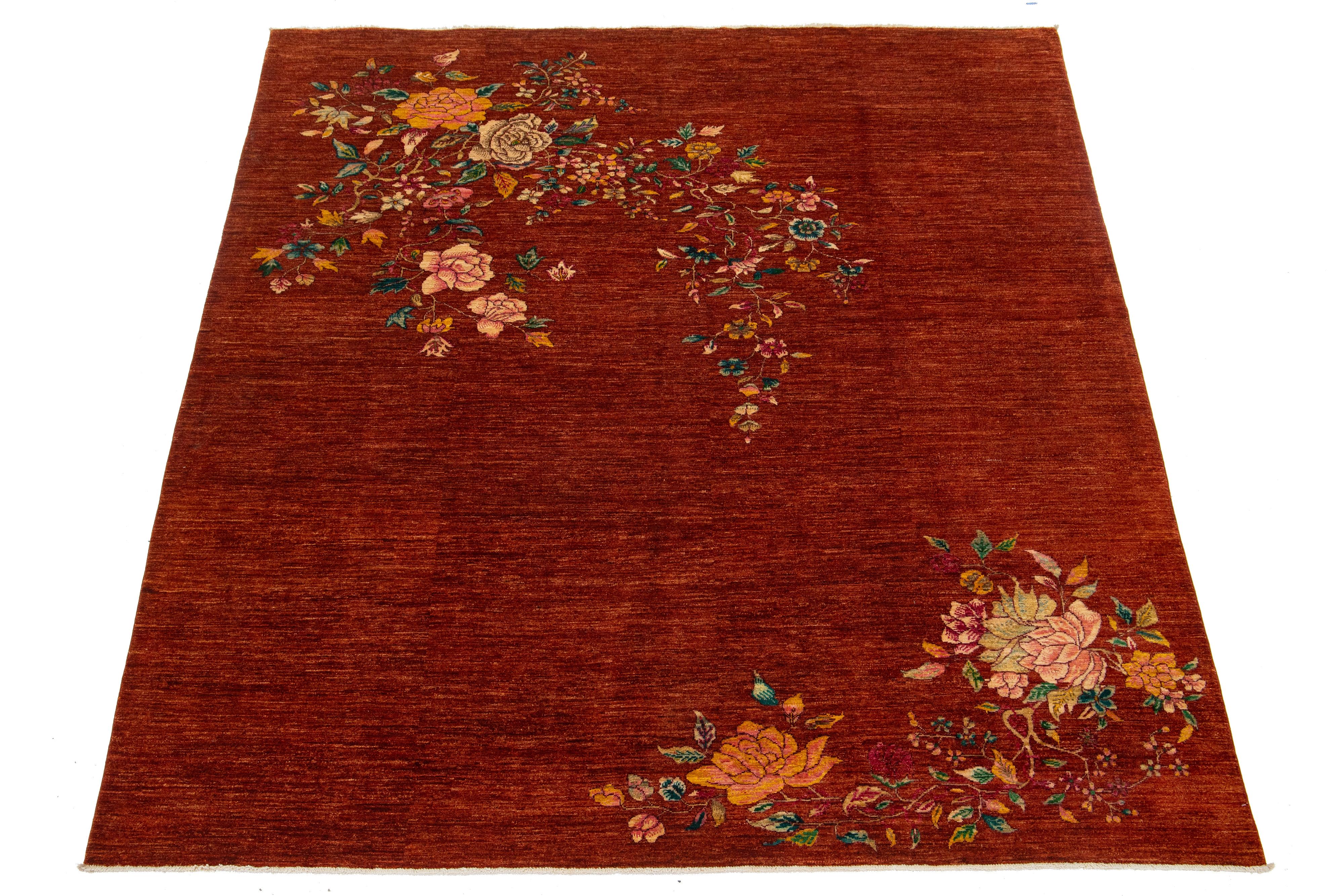 Tapis moderne en laine nouée à la main, de style chinois, avec un fond rouge terracotta et des accents multicolores vibrants représentant un motif floral chinois traditionnel.

Ce tapis mesure 8'2