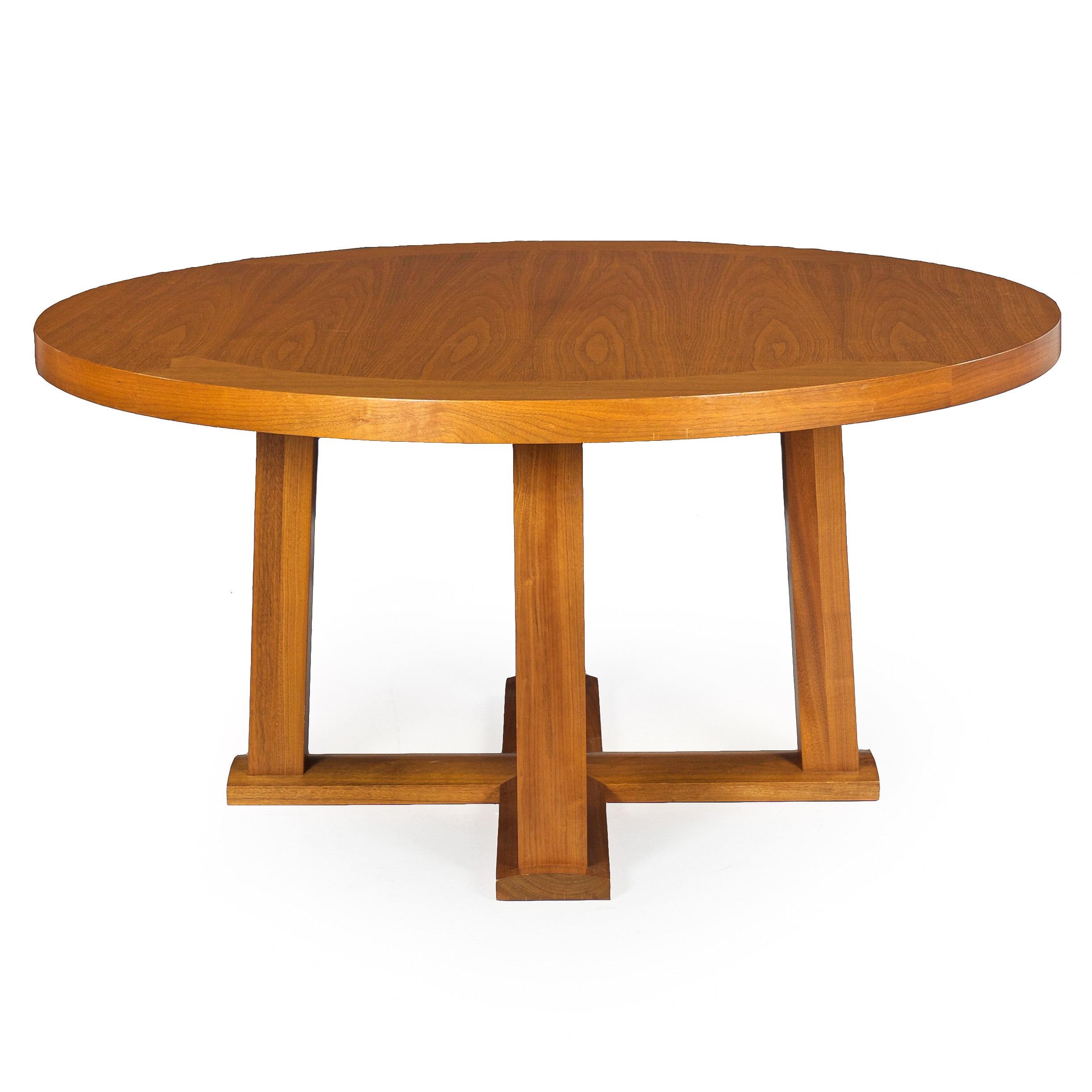 A fantastic circular dining table designed by Christian Liagre for Holly Hunt with the original label affixed to the underside, the piece features squared peg details in the rim surrounding the larger walnut surface with a generous edging; it is