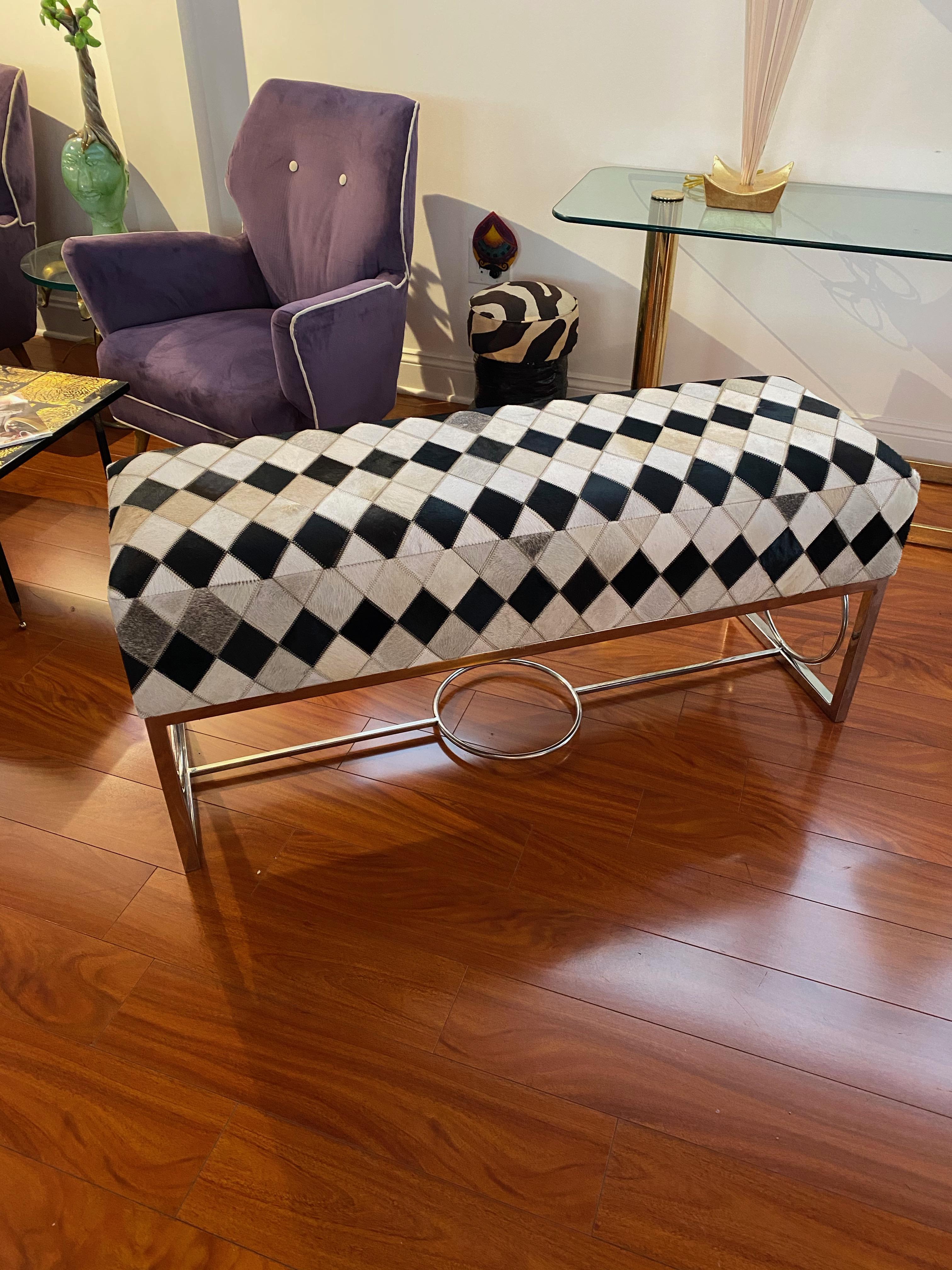 Modern bench having chrome frame and upholstered in cowhide. Having beautiful geometric designs throughout.