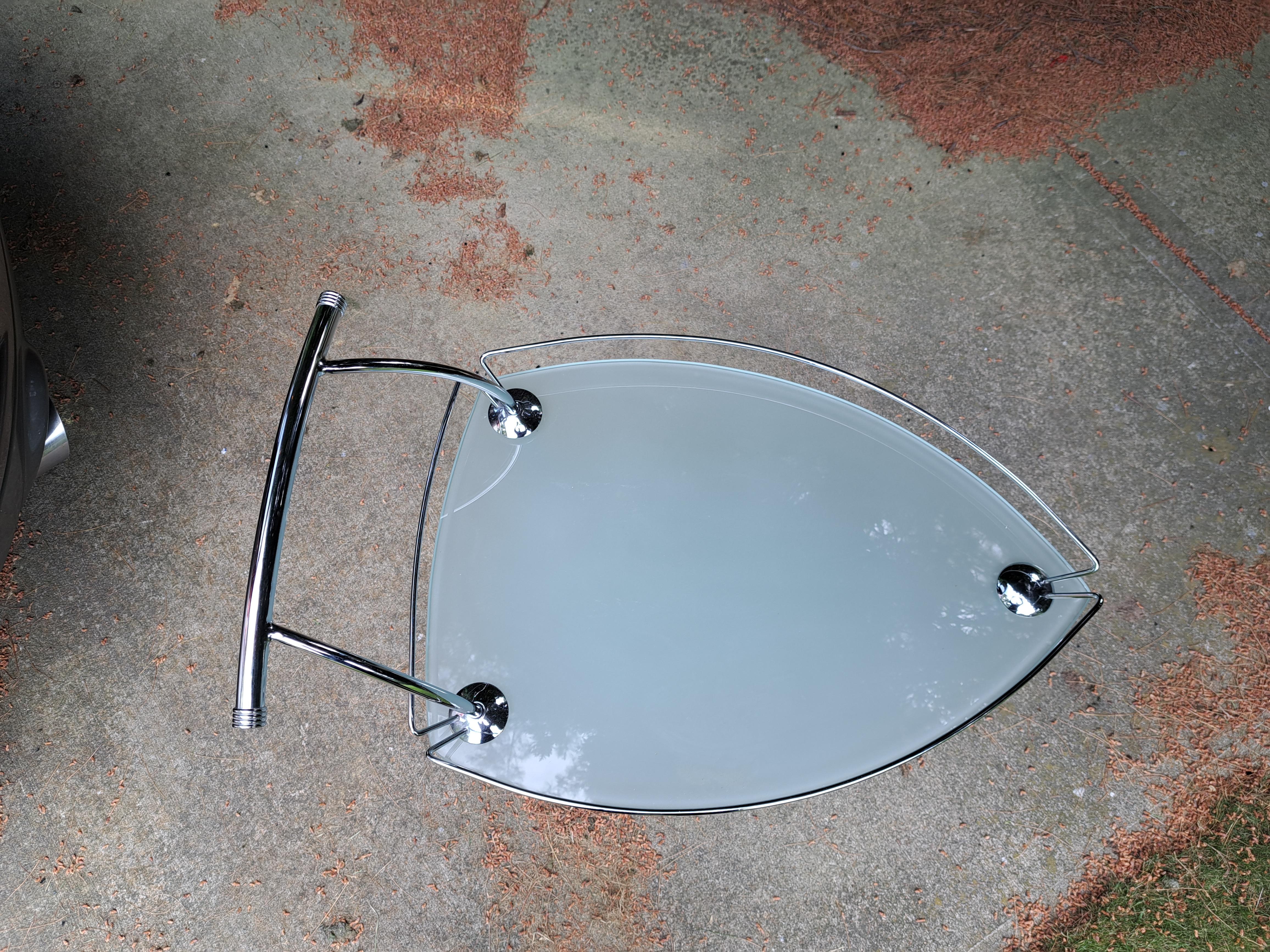 Unique triangular rolling glass and chrome bar cart. Sleek modern barware perfect for the next dinner party.