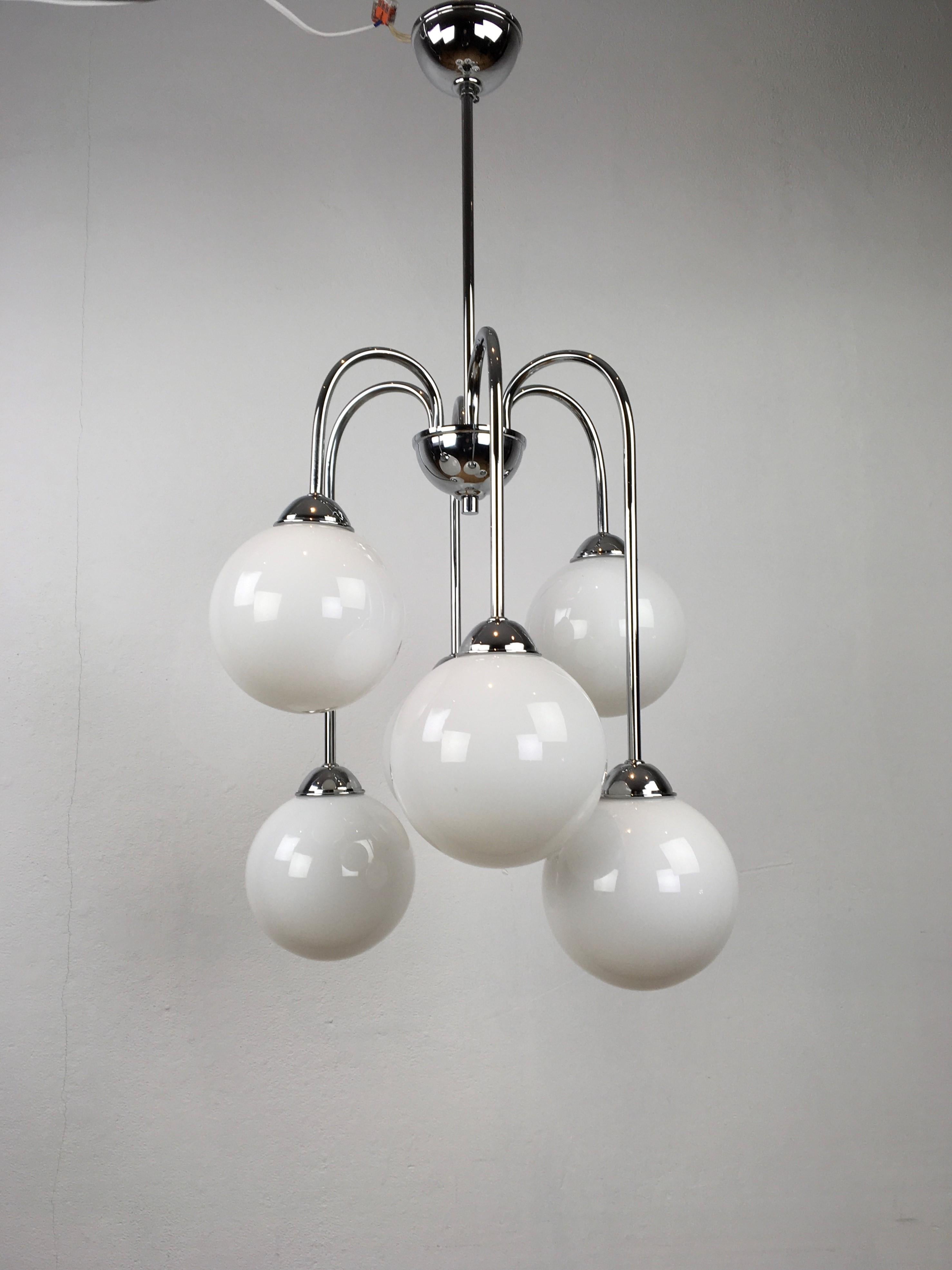 Modern chandelier with 6 lightpoints. 
Chromed metal frame with 6 opaline glass globes.
This opaline glass chandelier - milk glass chandelier will suit your interior well.