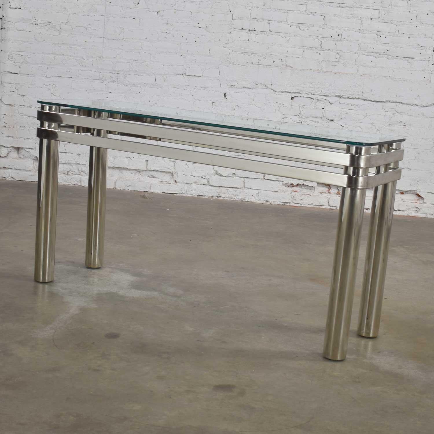 Stunning modern chrome rectangle console table or sofa table with glass top in the style of Pace or Karl Springer. Gorgeous vintage condition with wear consistent with age and the chrome plugs have been painted. Please see photos. Circa
