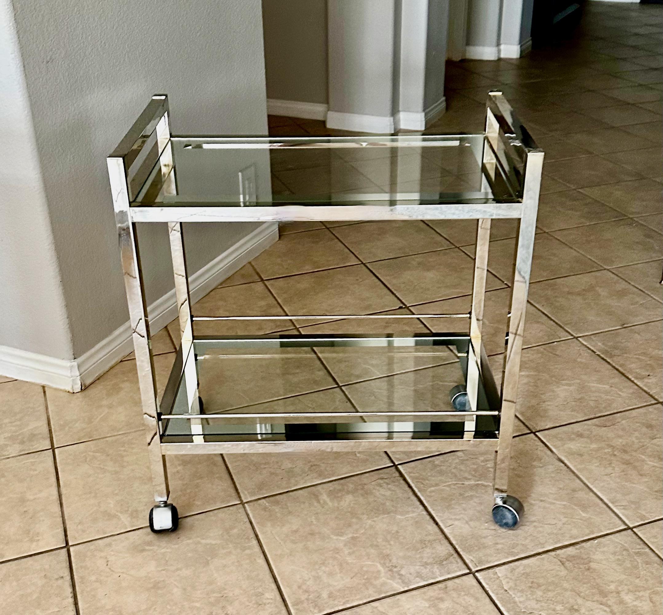 Modern two-tier bar cart with inset glass tops with mirrored edged detail and castor wheels. Height top of handles 29.5