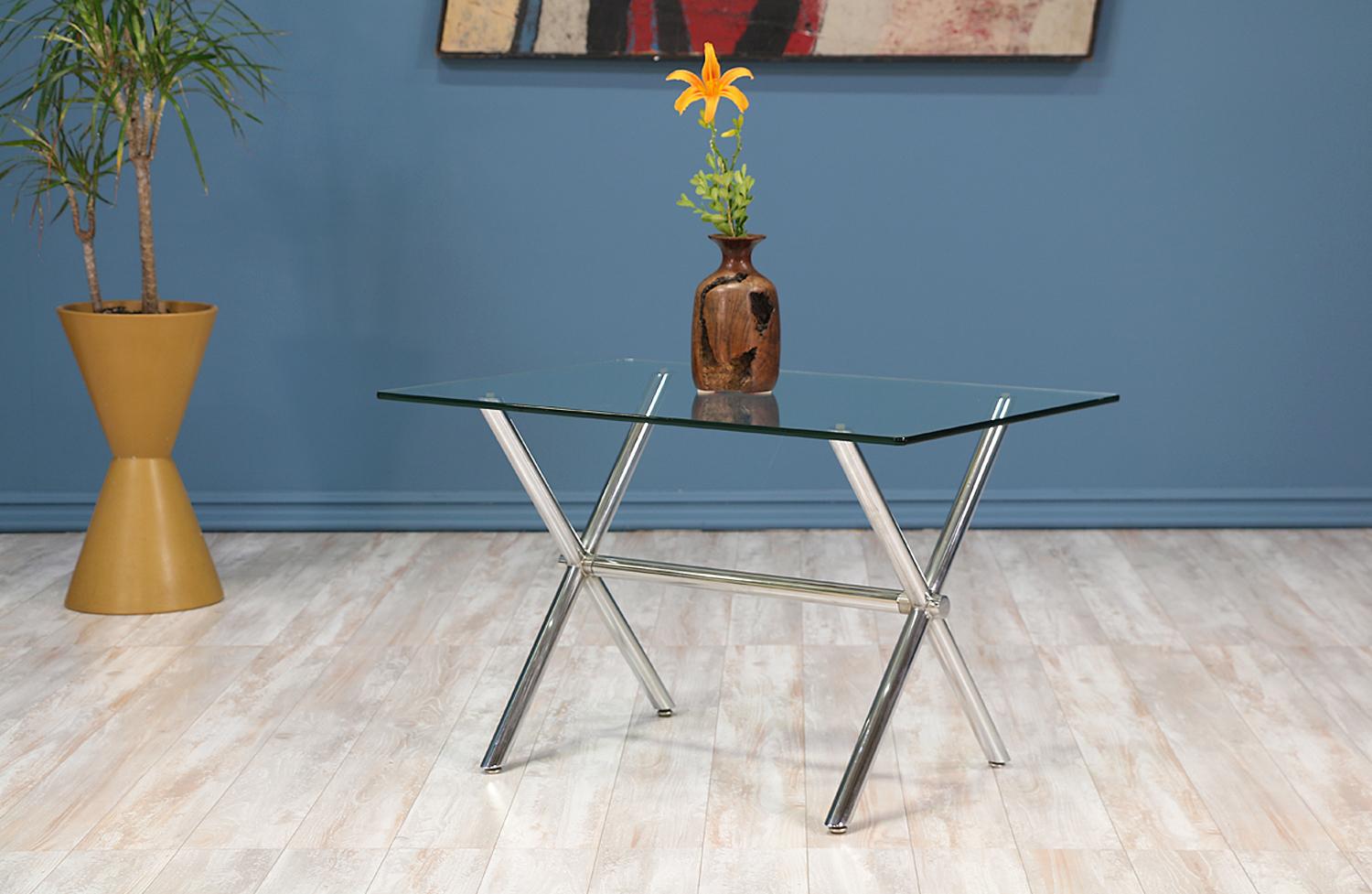 Sleek modern side table with a welded chromed steel ‘X’ base reminiscent of the campaign-style. The rectangular glass top complements its clean aesthetic.

ID number: 5236.