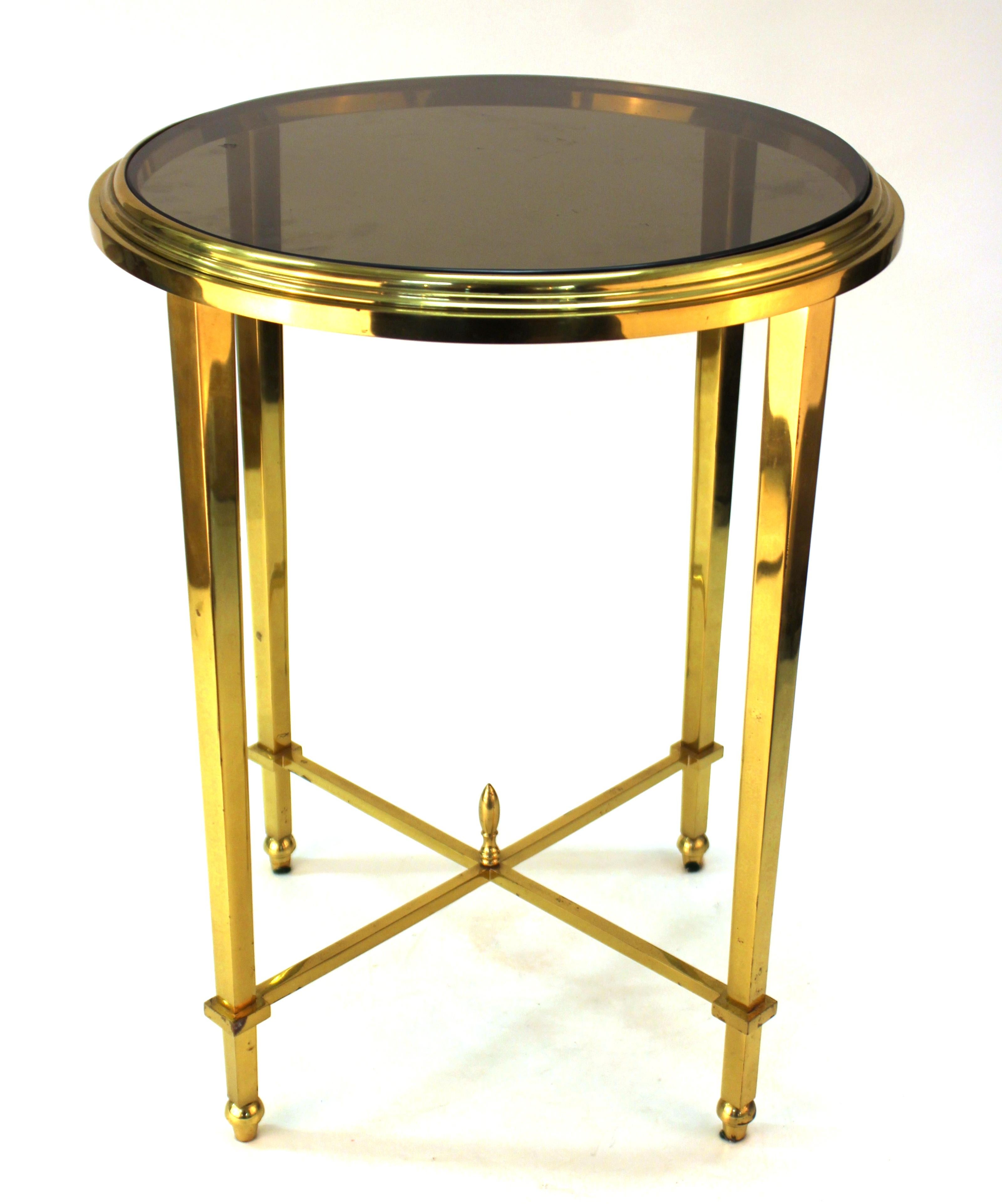 Modern classical style side table or end table in a metal round frame with a smoked glass top. The piece is in good vintage condition with some wear and patina to the legs.