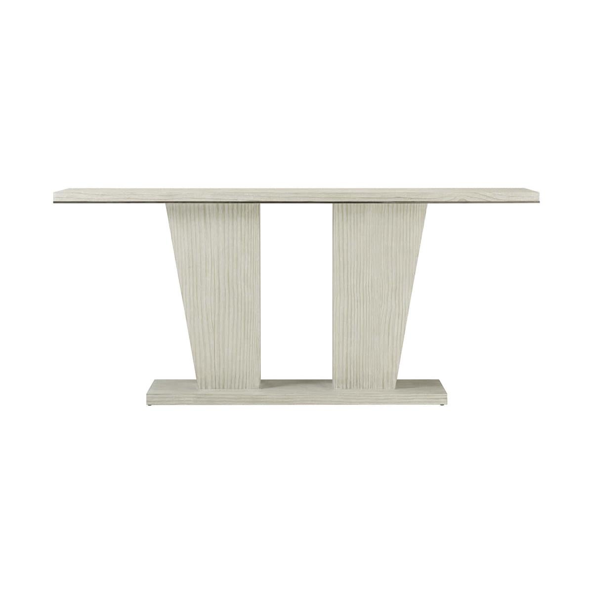 A modern coastal console table, exquisitely crafted from quartered pine highlighted by a double pedestal base and decorative tapering supports in our wire brushed cerused pine Sea Salt finish.

Dimensions: 76