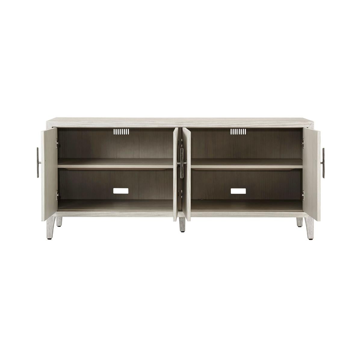 Introducing the Modern Coastal Entertainment cabinet, a stunning addition to any entertainment space. This elegant four-door console is crafted from wire-brushed cerused pine in a beautiful Sea Salt finish, creating a warm and inviting atmosphere in