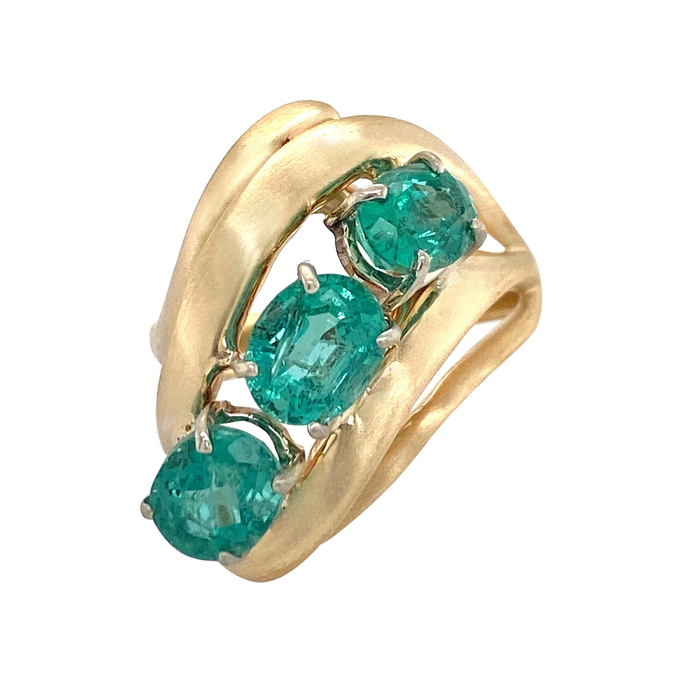 Modern Cocktail Ring Featuring Three Oval Emeralds in Yellow Gold, Circa 1970 For Sale
