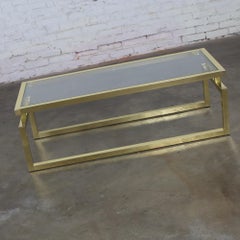 Mesa de centro moderna con estructura de aluminio anodizado en tono latón y tablero de cristal