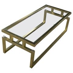 Tavolino moderno con struttura in alluminio anodizzato color ottone e piano in vetro