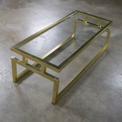 Mesa de centro moderna con estructura de aluminio anodizado en tono latón y tablero de cristal