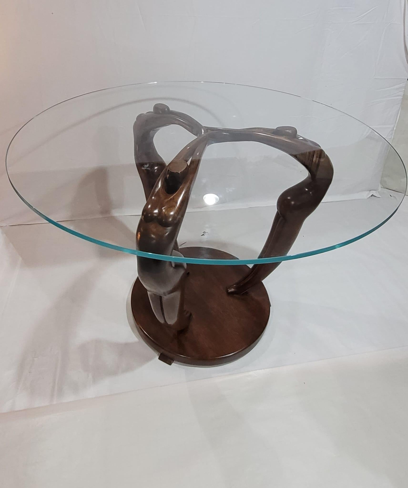 Fusion captivante de l'art et de la fonction, cette table de salle à manger est sculptée à la main dans un bloc de noyer massif, donné vie par un designer ayant plus de 35 ans de maîtrise sculpturale. Trois figures humaines abstraites, fluides et