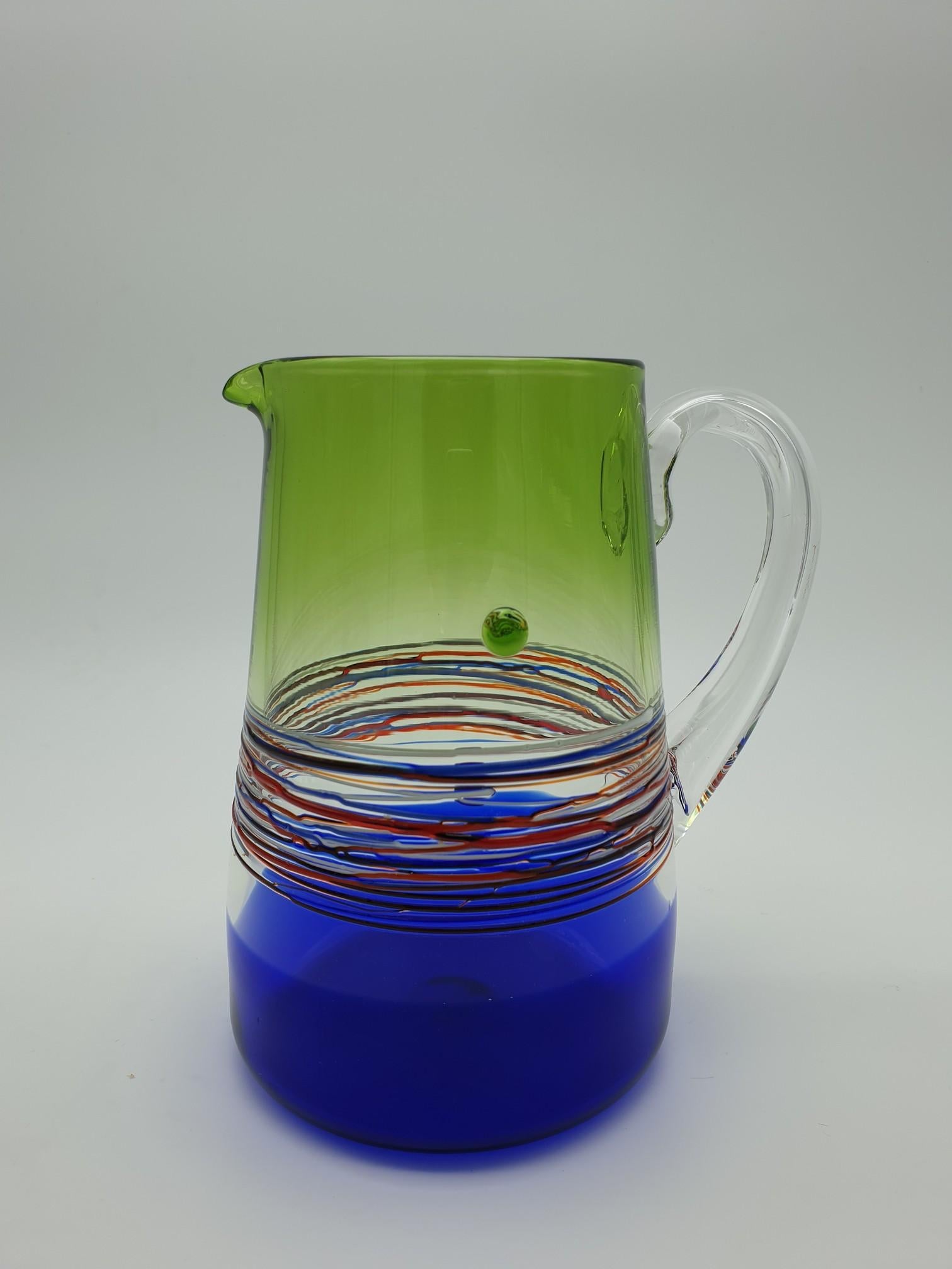 Modern colorful Murano glass pitcher or jug made by Gino Cenedese e Figlio in the late 1990s. This beautiful pitcher has been carefully handmade and features a clear handle and colorful splashes of bright green color on the top and royal blue on the