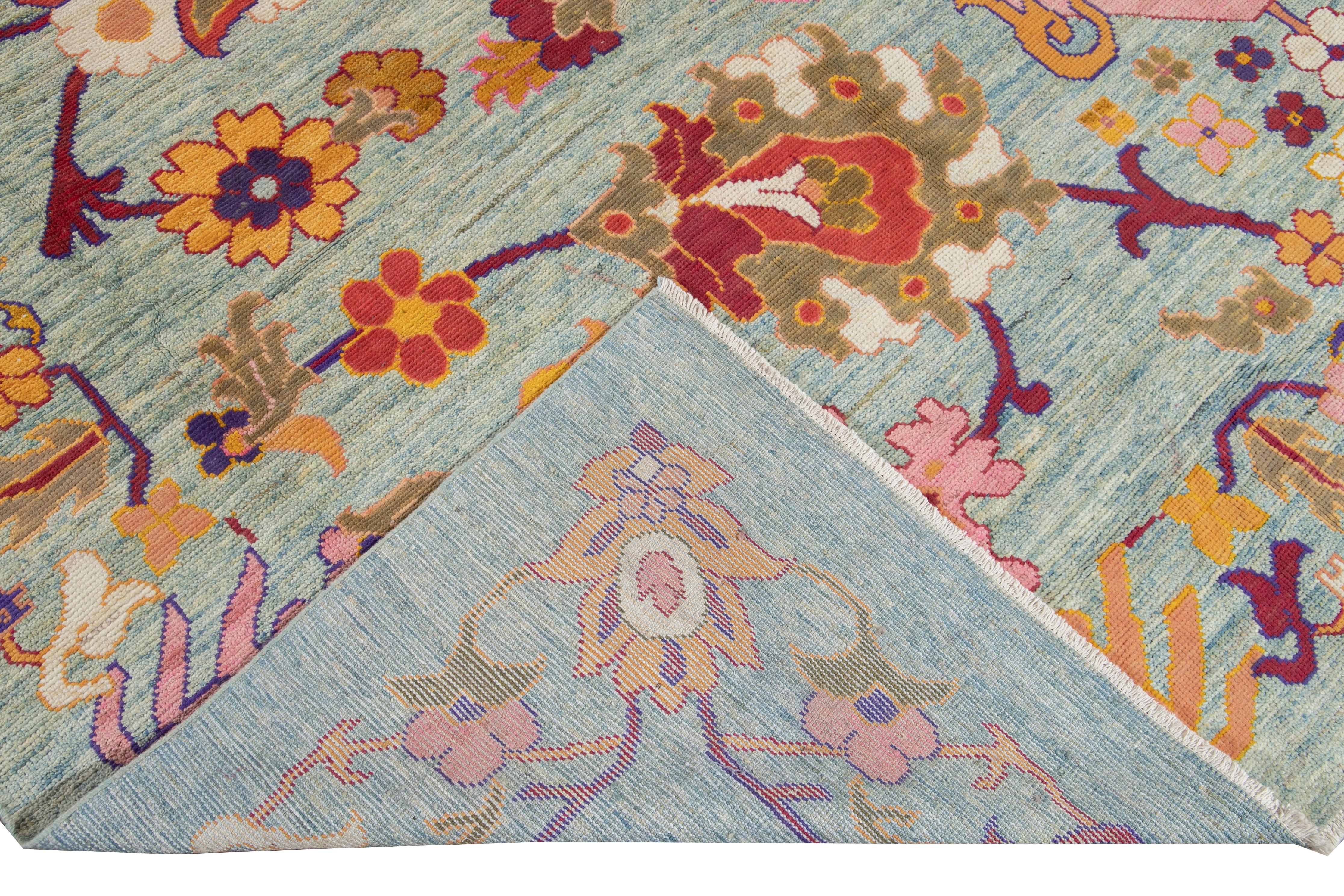 Magnifique tapis moderne Oushak surdimensionné en laine nouée à la main avec un champ bleu. Ce tapis Oushak présente des accents multicolores sur un magnifique motif floral botanique. 

Ce tapis mesure : 12' x 16'3