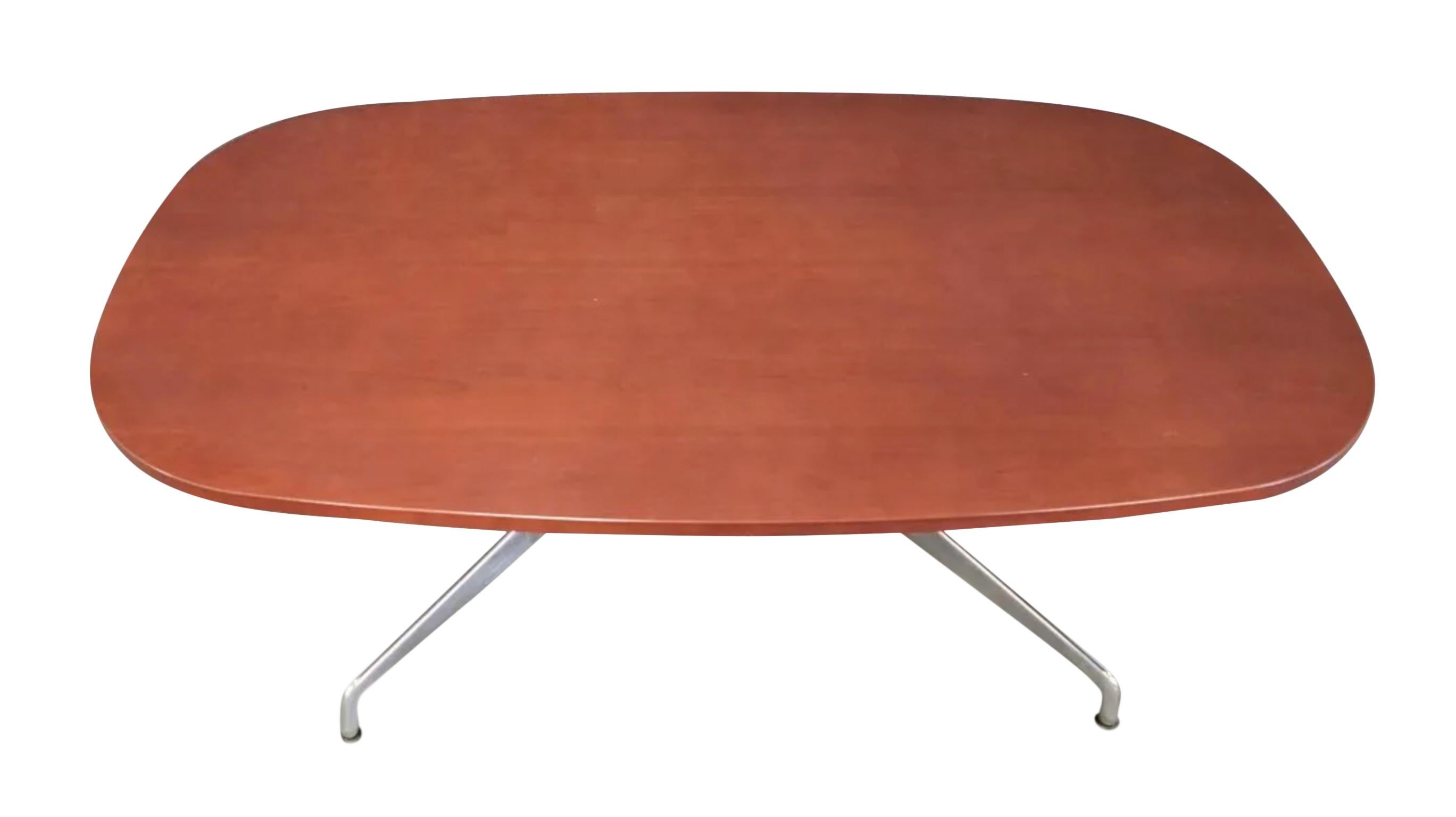 Modern Pre Owned Herman Miller Eames conference or dining table. On polished chrome and aluminum segmented base. This table is Modern. Has a reddish brown wood tone. Located in Brooklyn NYC.

Measures: Very comfortably fits 6 chairs.
knee hole