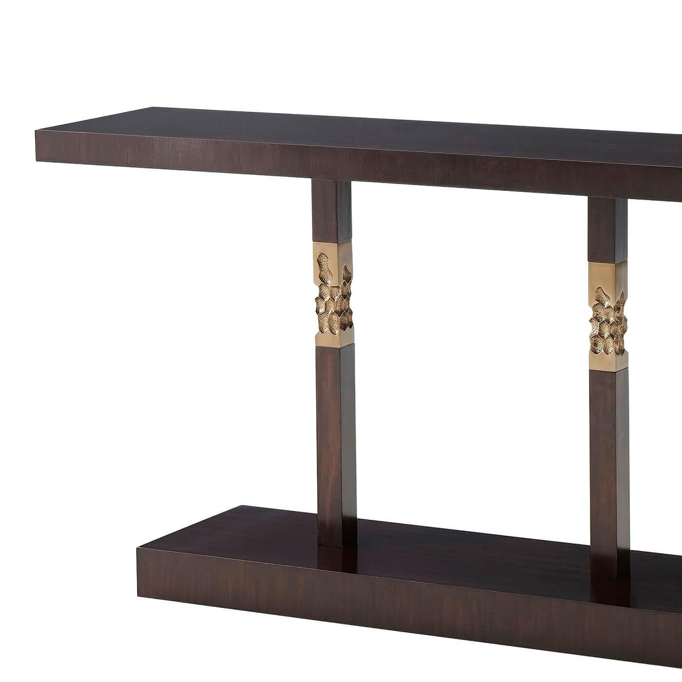 Table console moderne en acajou massif et placage dans une finition espresso avec des colonnes carrées brutalistes accentuées de laiton texturé.
Dimensions : 80