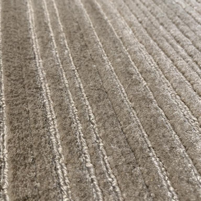 Traditional striae effect injected with shimmery silk highlights brings out the glamour in this simple yet highly attractive rug design. Artfully crafted and knotted, this rug offers textural interest through the use of a highland soft Tibetan wool